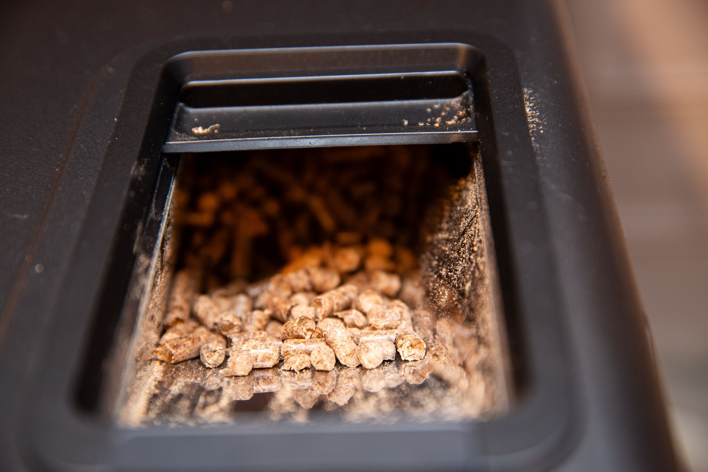 <em>Wood pellets go in the top of the smoker. A bag of wood pellets from Kona comes with it. GE Appliances says you can use any pellets designed for pellet grills or smokers.</em> 