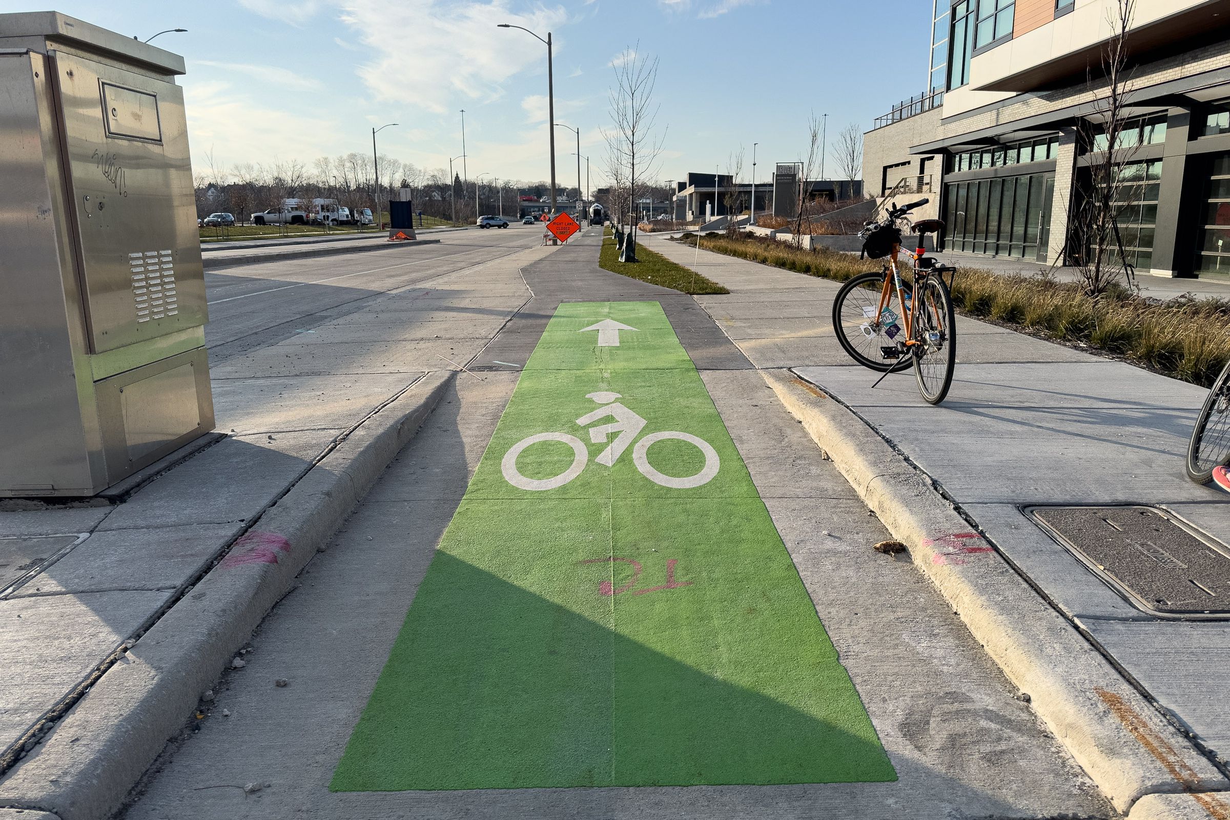 A picture of green paint indicates that a portion of this sidewalk is intended for cyclists only.