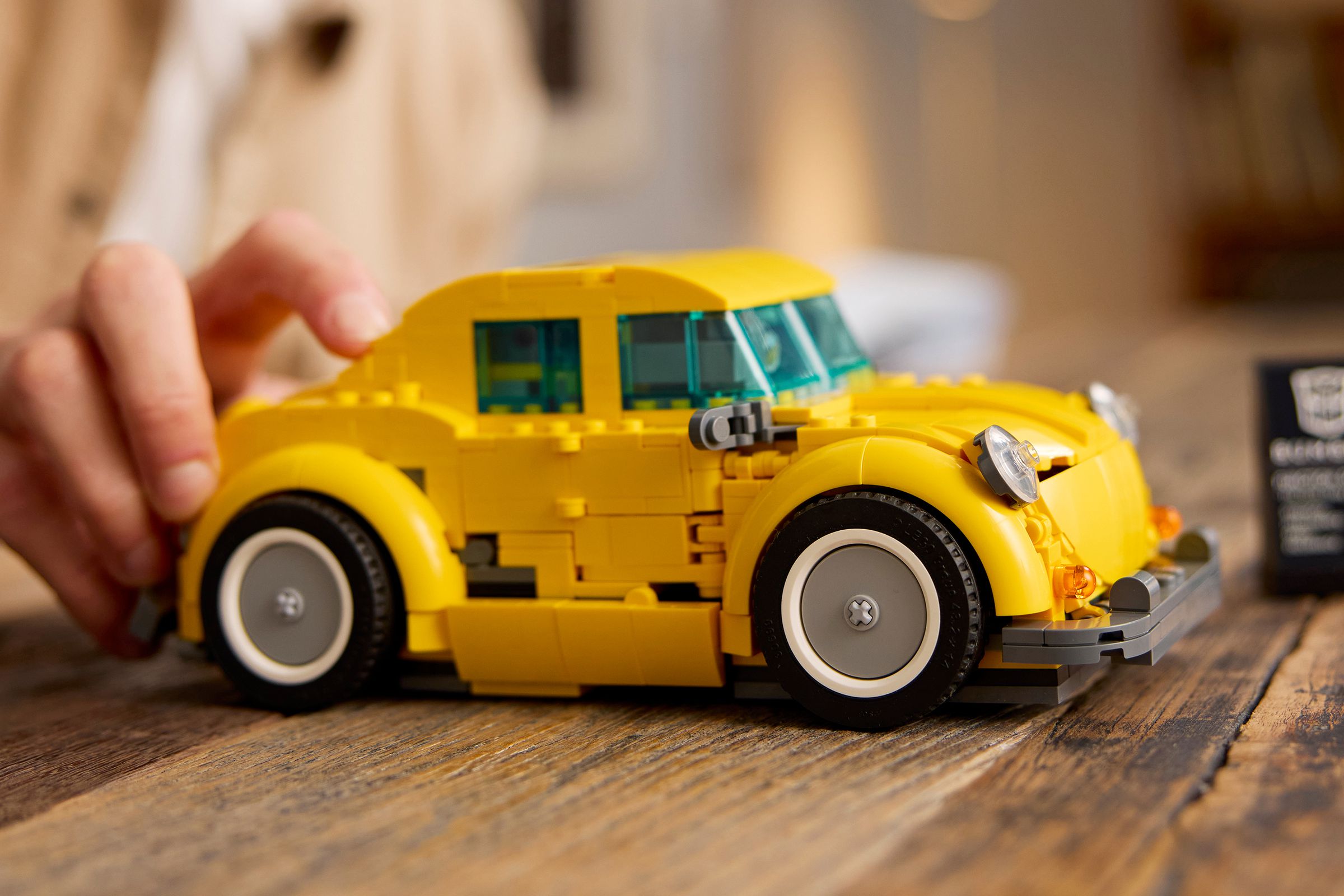 Lego’s buildable Bumblebee model in vehicle mode on a wooden table.