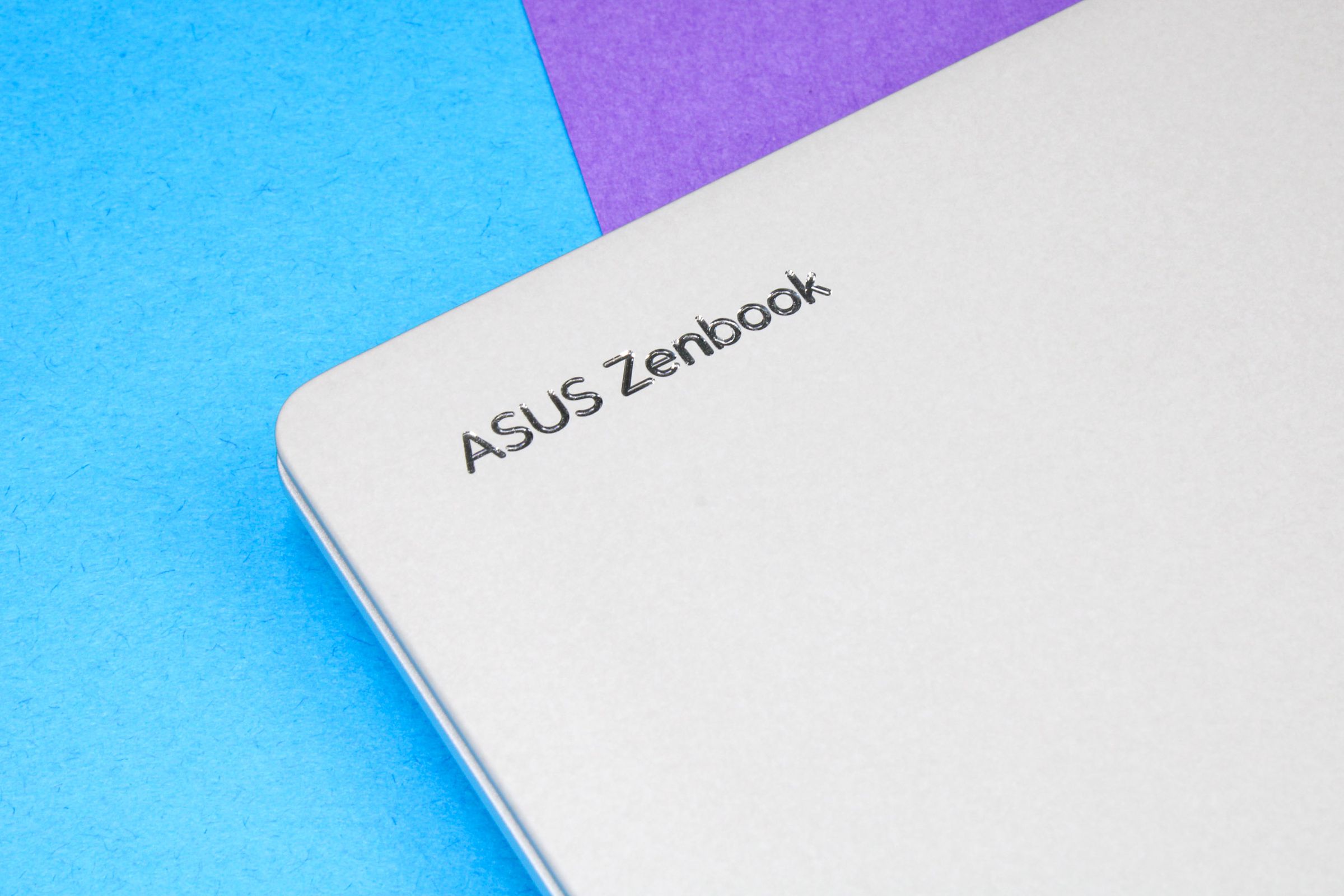 A close up of the words ‘Asus Zenbook” near the corner of the laptop lid.