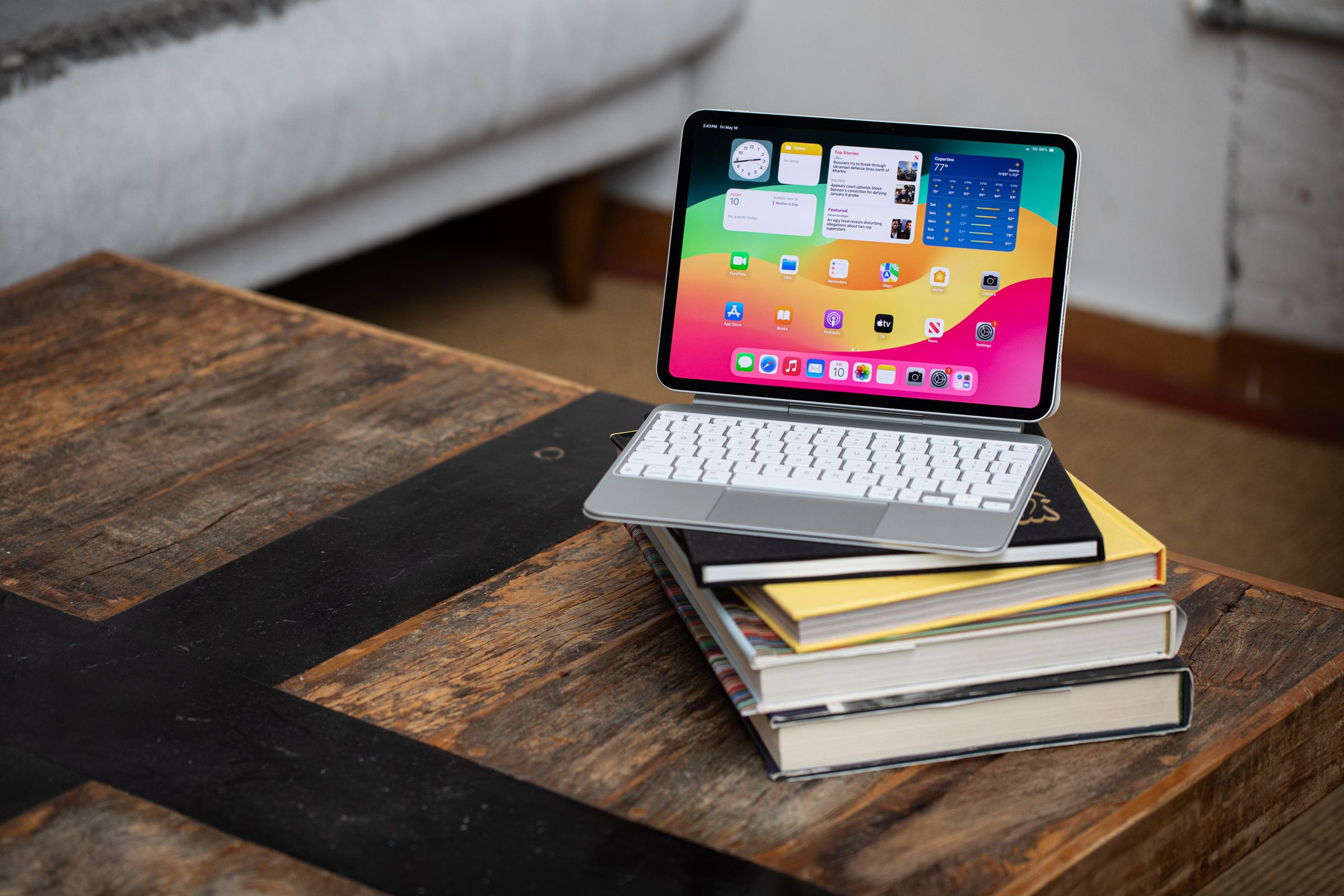 The 2024 iPad Pro with a keyboard folio case sitting atop some books on a table.