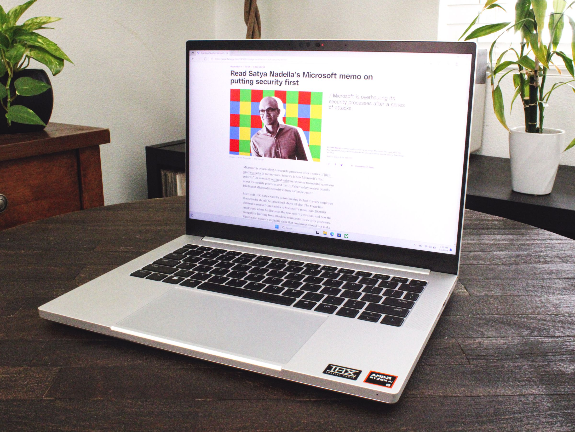 An open and powered on laptop sitting on top of a dark brown wood table.