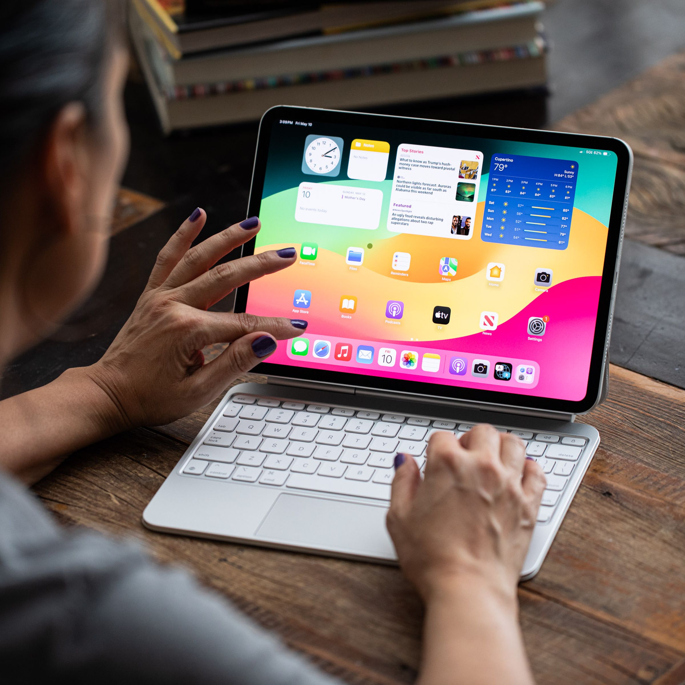 A photo of a person pinching the screen on an iPad Pro.