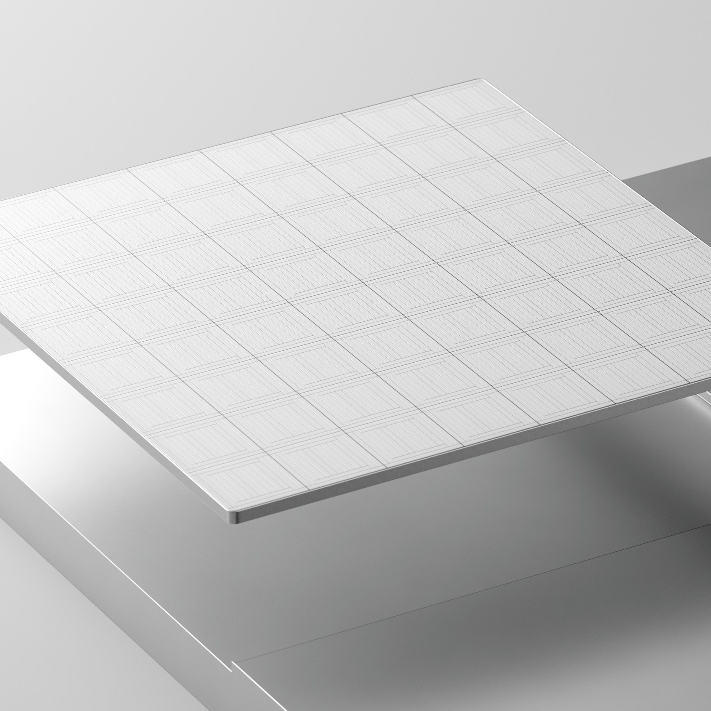 A white tile representative of a computer chip above a shiny silver metal surface that the chip appears to have been milled out of
