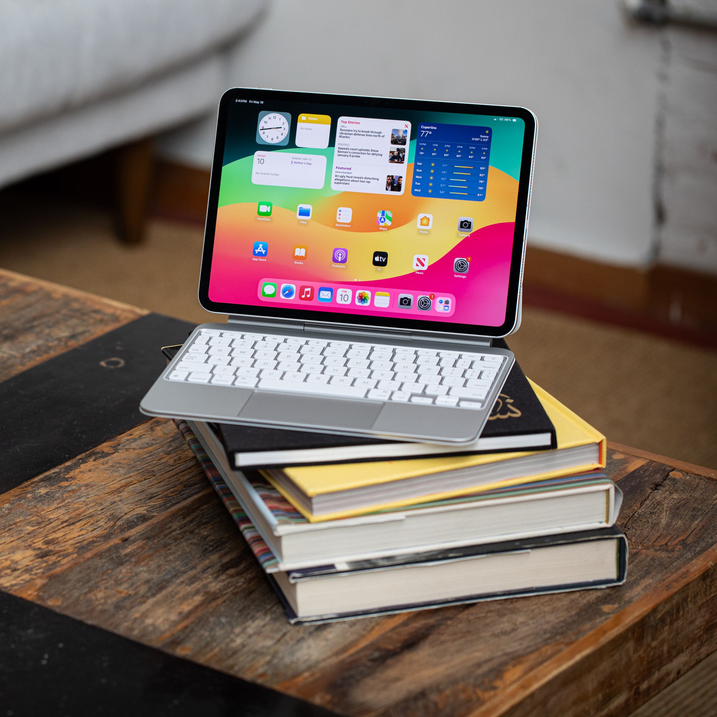 The 2024 iPad Pro with a keyboard folio case sitting atop some books on a table.