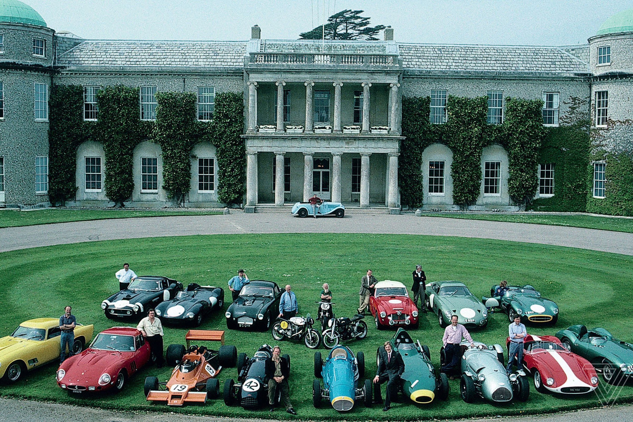 The cast of cars and characters from the first Goodwood press day in 1993. Lord Charles March is by the front door of the house with his light blue AC 16/80 designed by his grandfather.