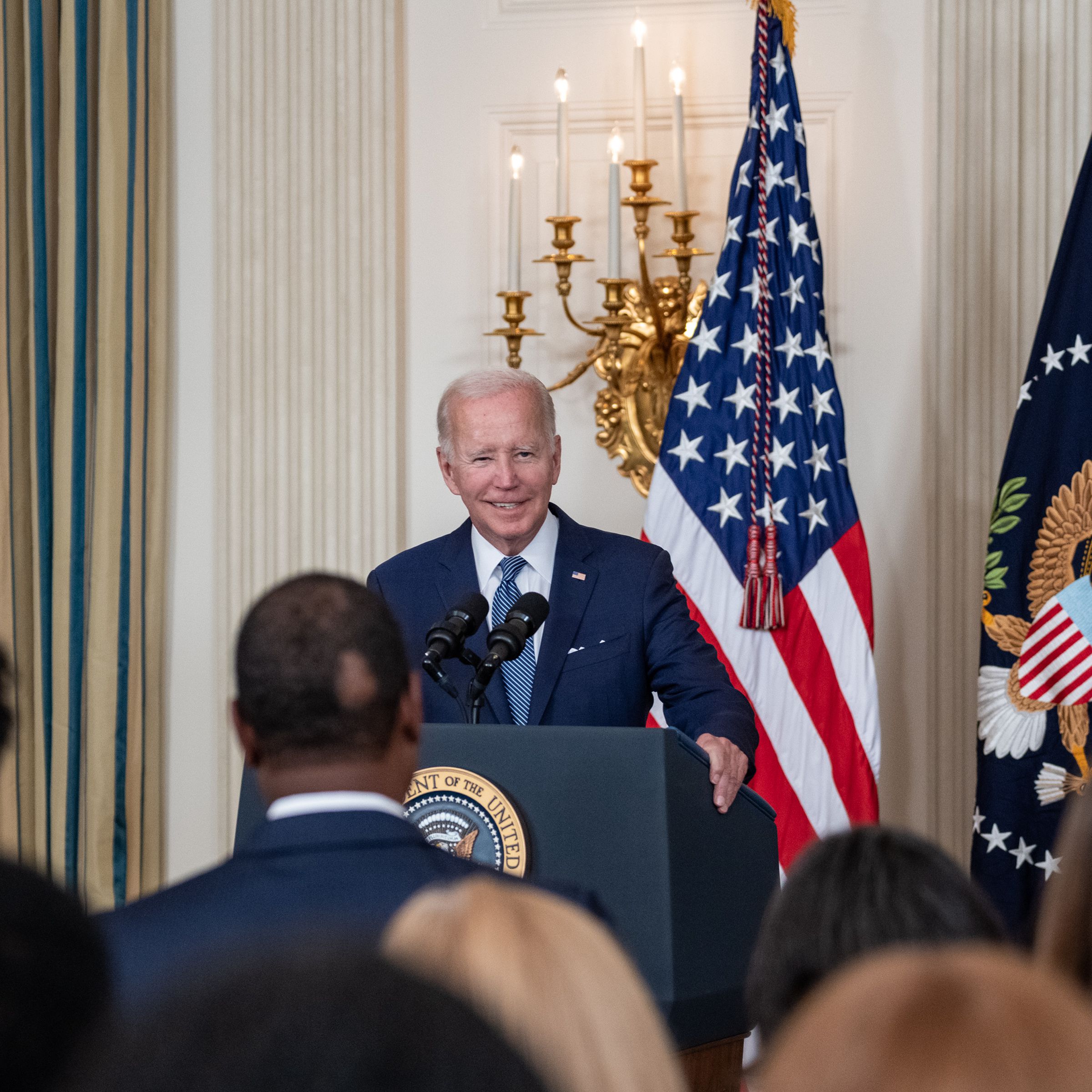 Joe Biden speaks at a podium in front of a crowd.