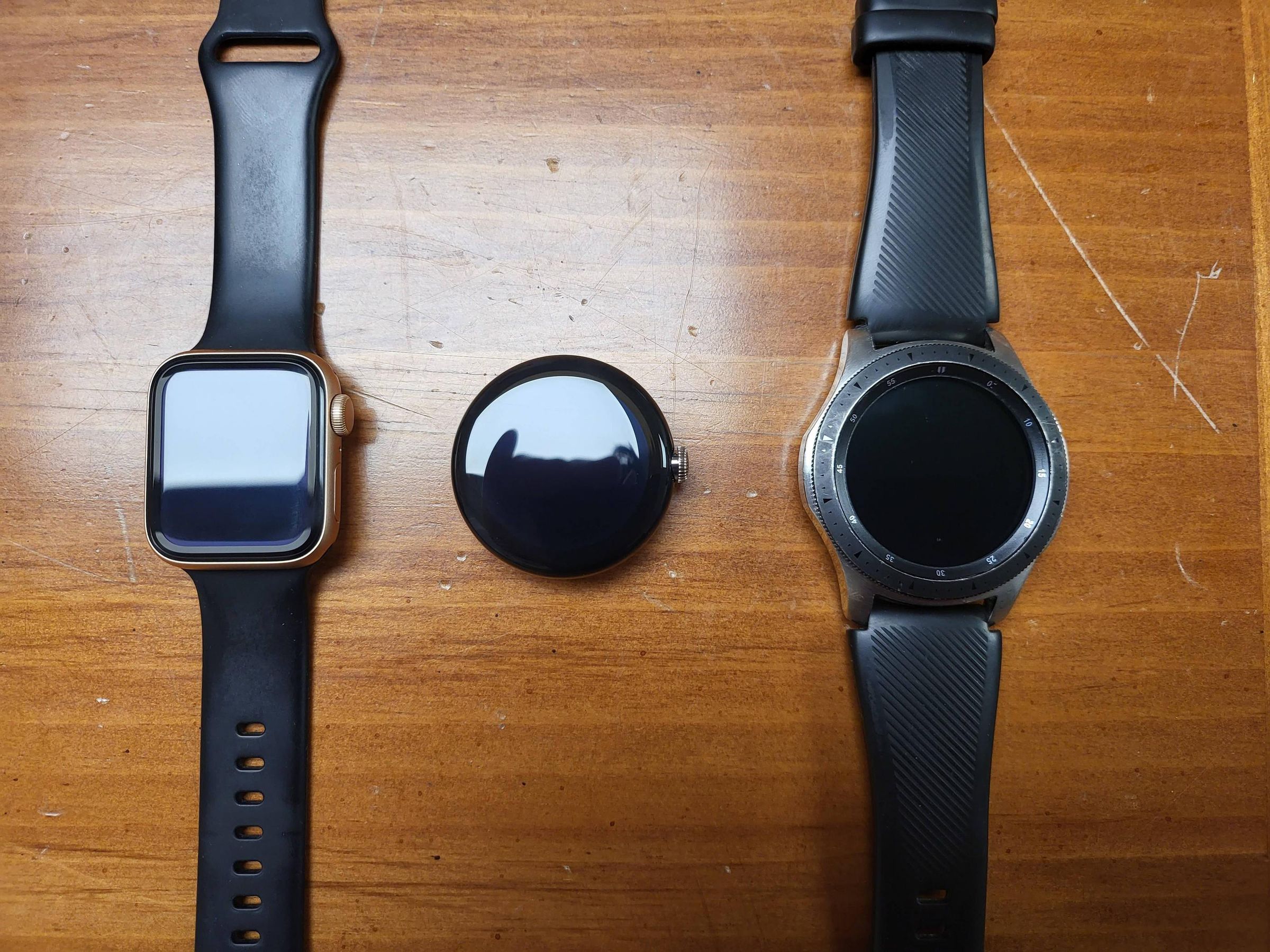 A leaked Pixel Watch prototype between a 40mm Apple Watch (left) and a 46mm Samsung Galaxy Watch.