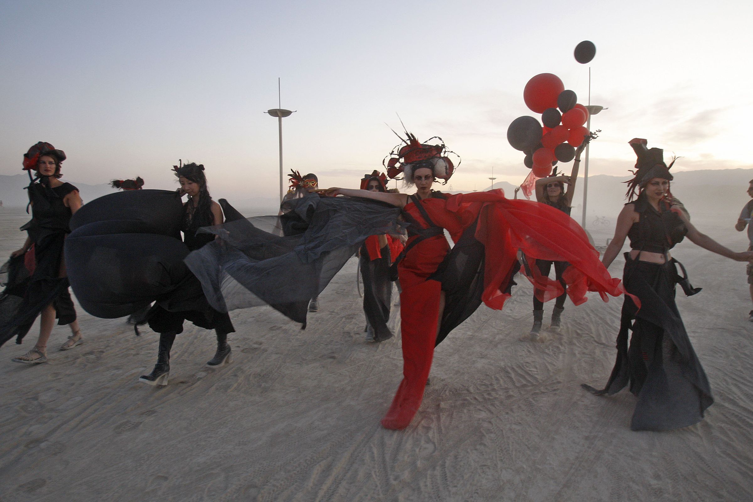 Performing artists dance on the playa during a dust storm. 