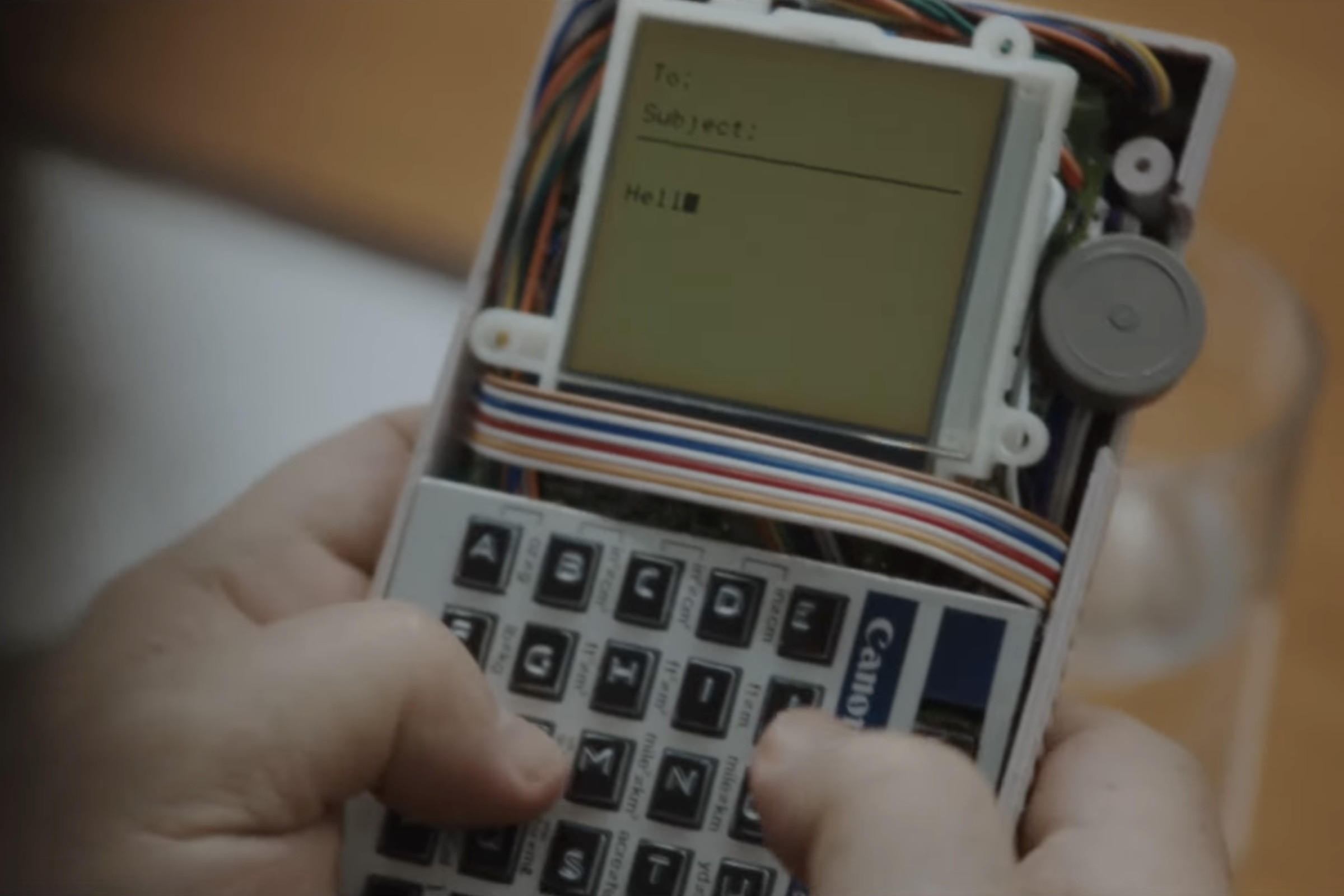 Screenshot of a frame showing someone typing on a prototype BlackBerry