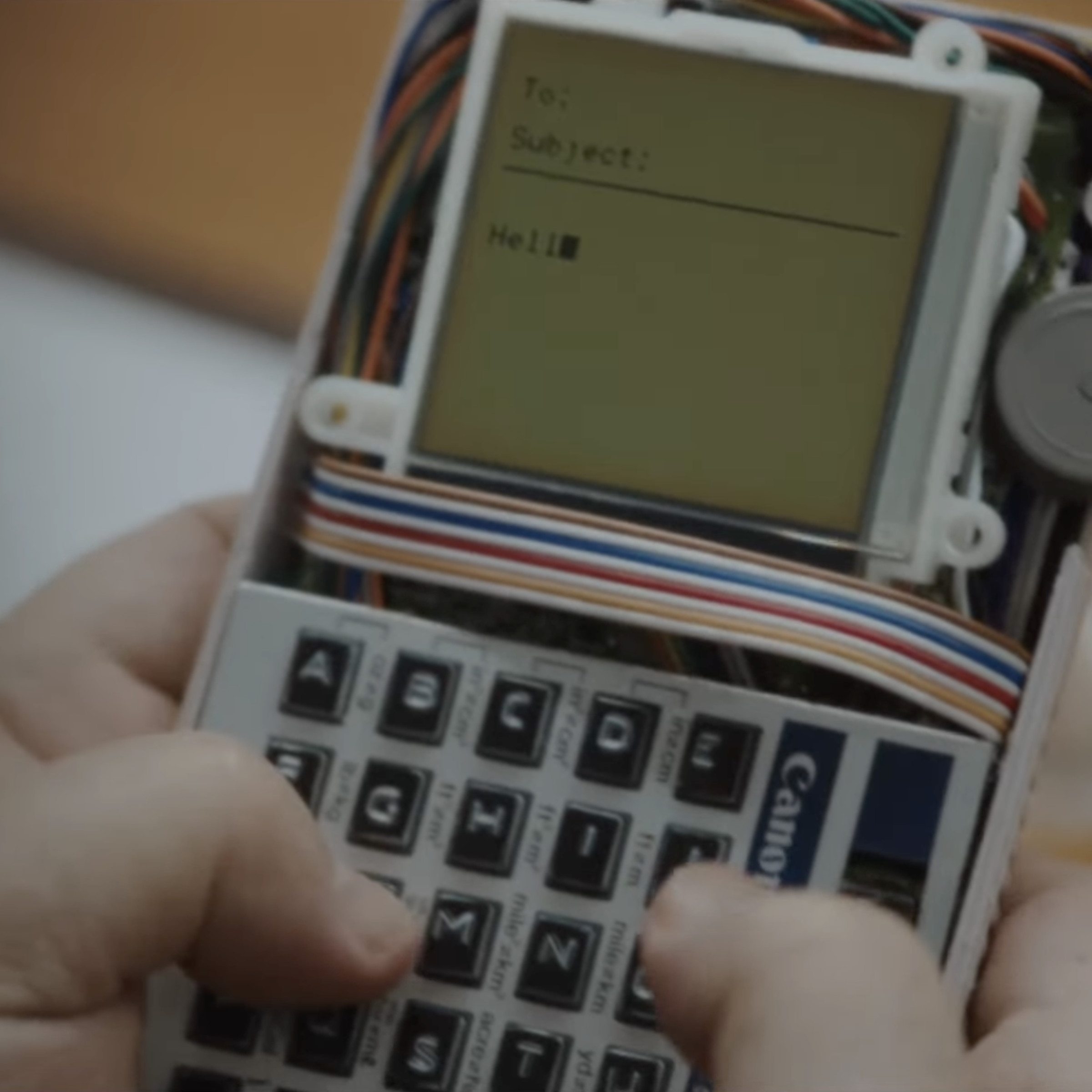 Screenshot of a frame showing someone typing on a prototype BlackBerry