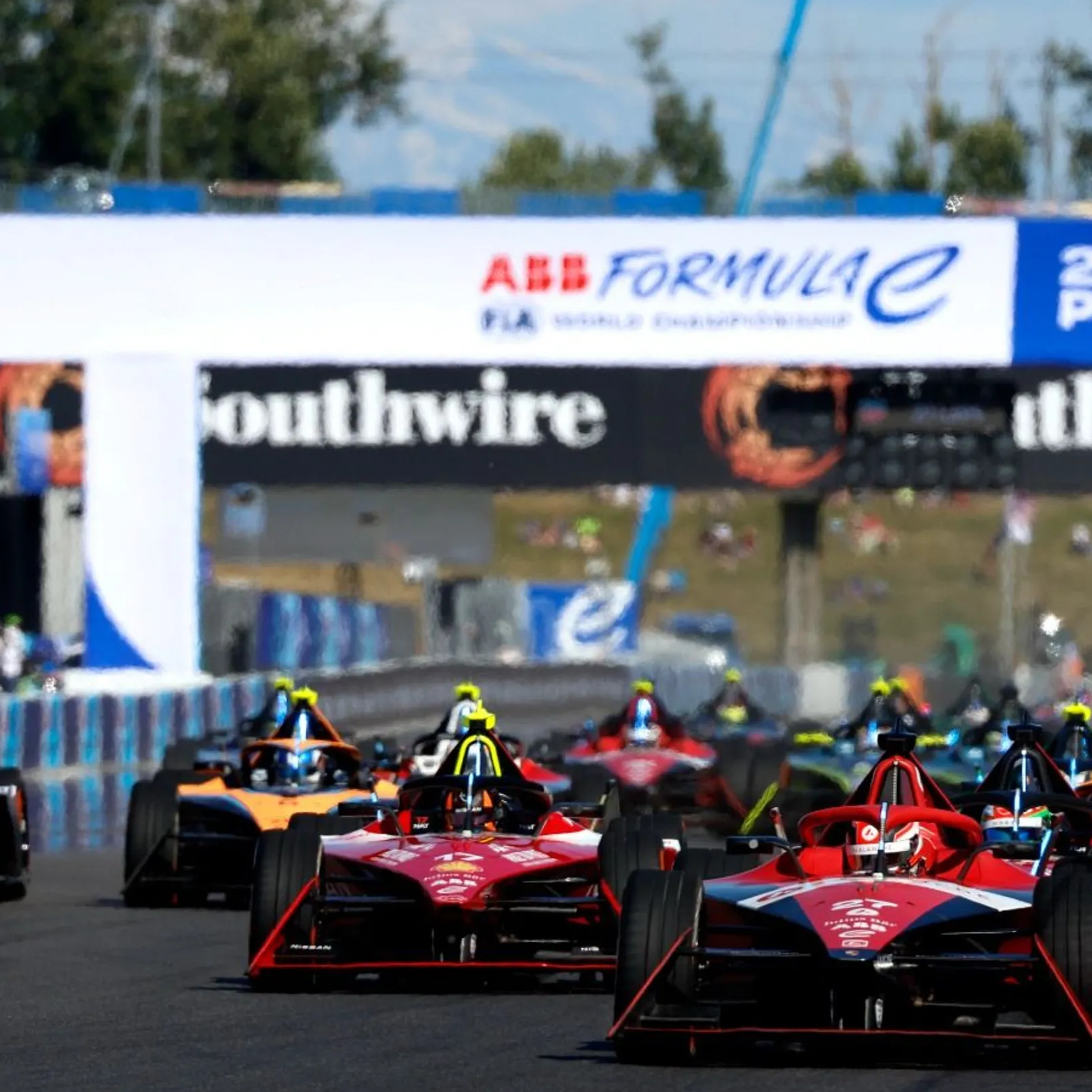 An image of several Formula E cars on the track.