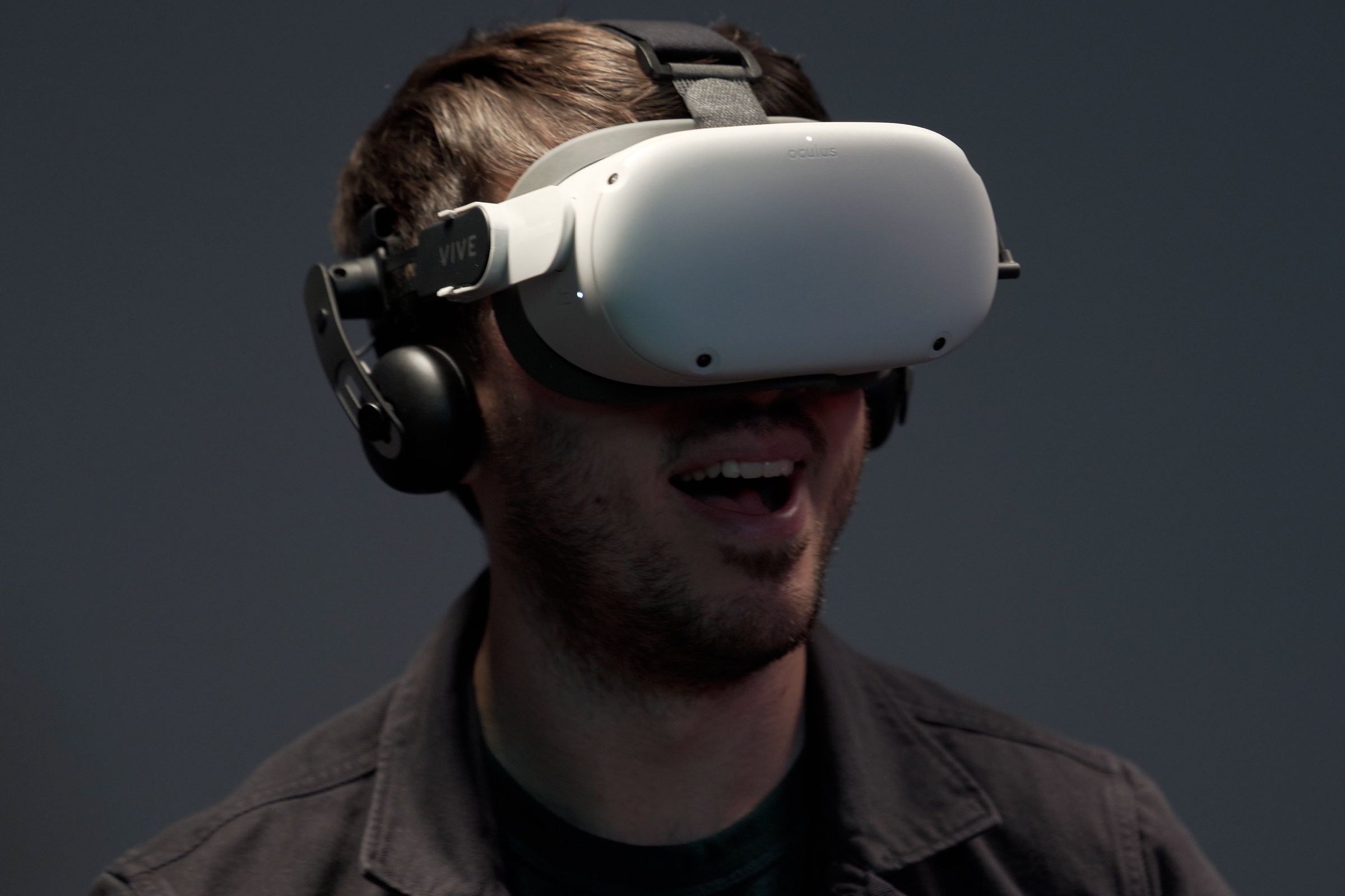 former verge staff Cameron Faulkner joyfully wears a meta quest 2 with an htc vive deluxe audio strap