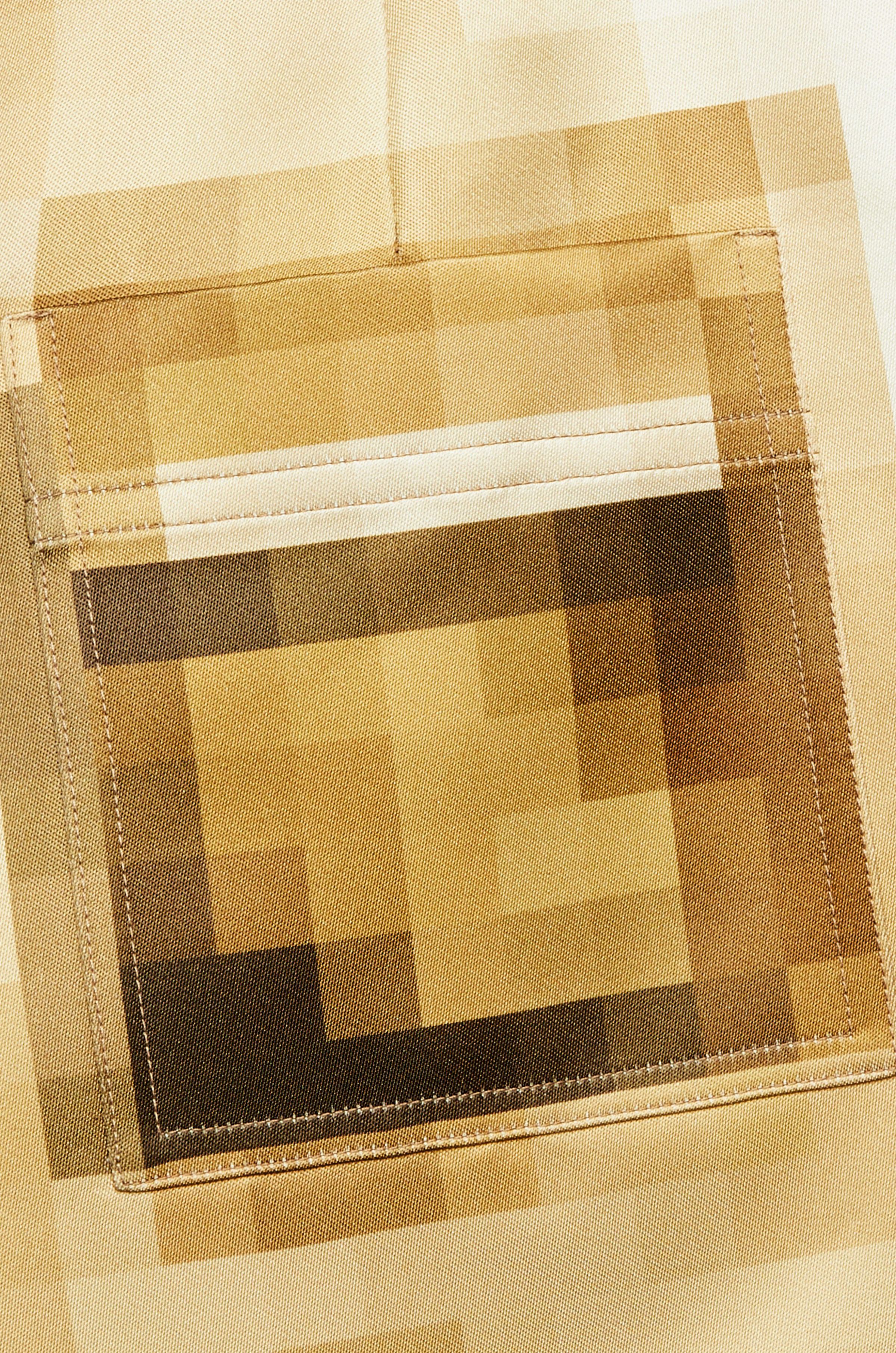 A close up image of a pair of tan trousers, designed to look pixelated from a distance.