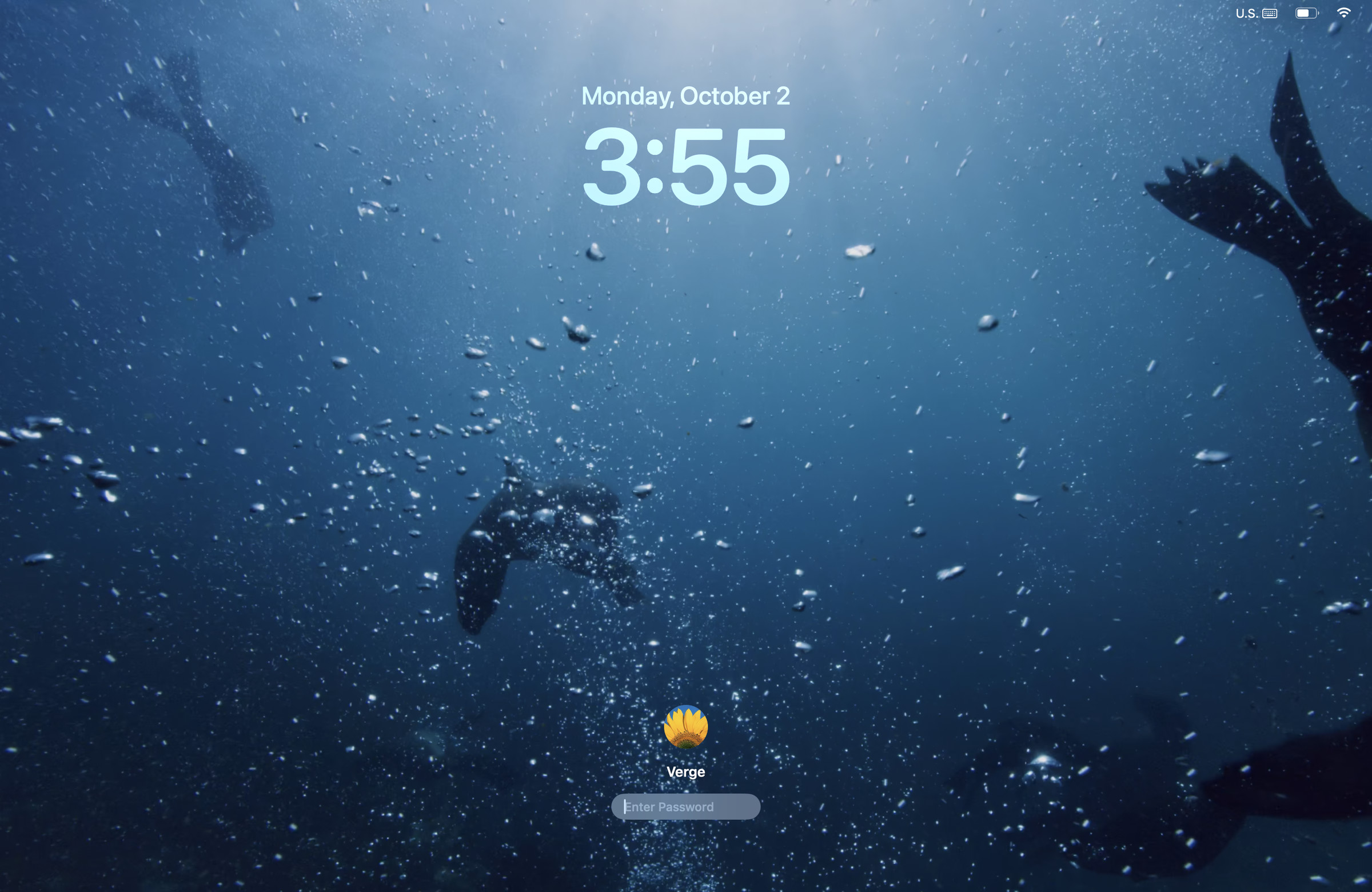 A screenshot of the swimming seals macOS Sonoma wallpaper on the macOS lockscreen.