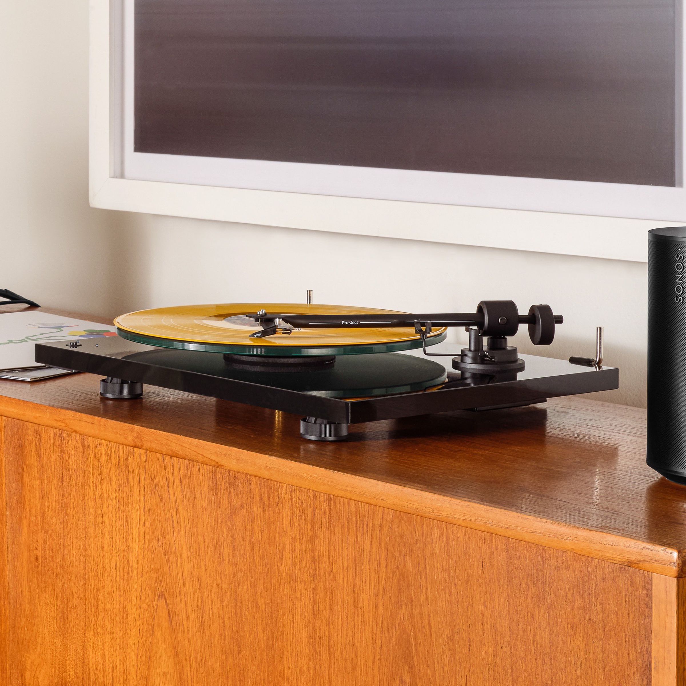 A marketing images of two Sonos Era 100 speakers with a turntable in the center.
