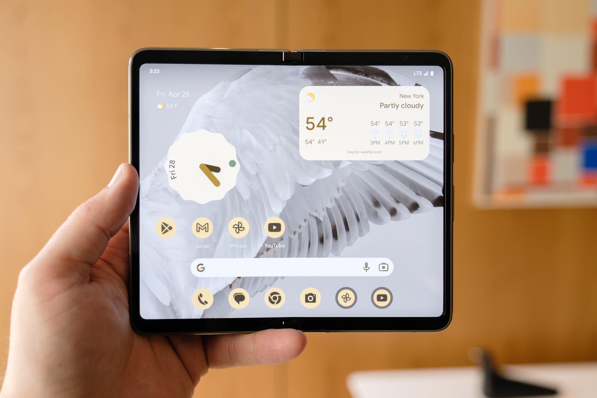 Google’s Pixel Fold opened in its tablet form, held up by a hand.