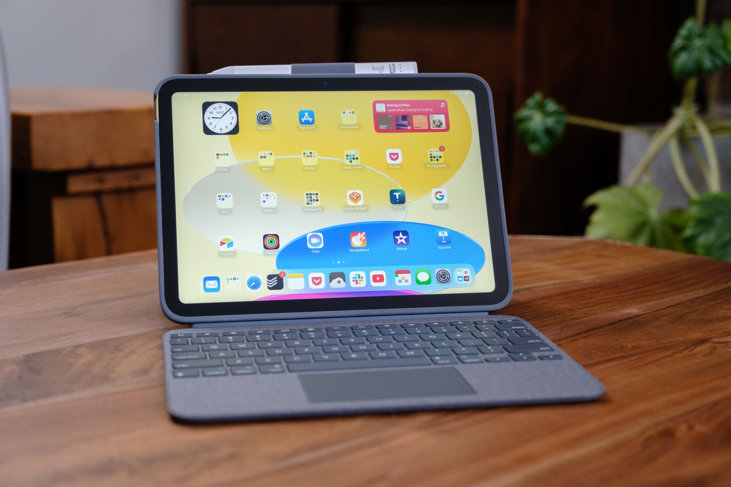 A 10th Gen iPad in a Logitech Combo Touch keyboard case on a wood table.