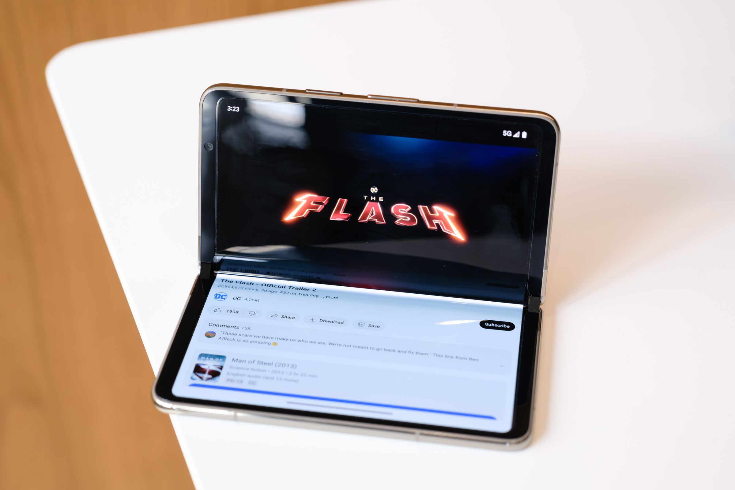 A partially opened Pixel Fold playing a YouTube video on its top half.