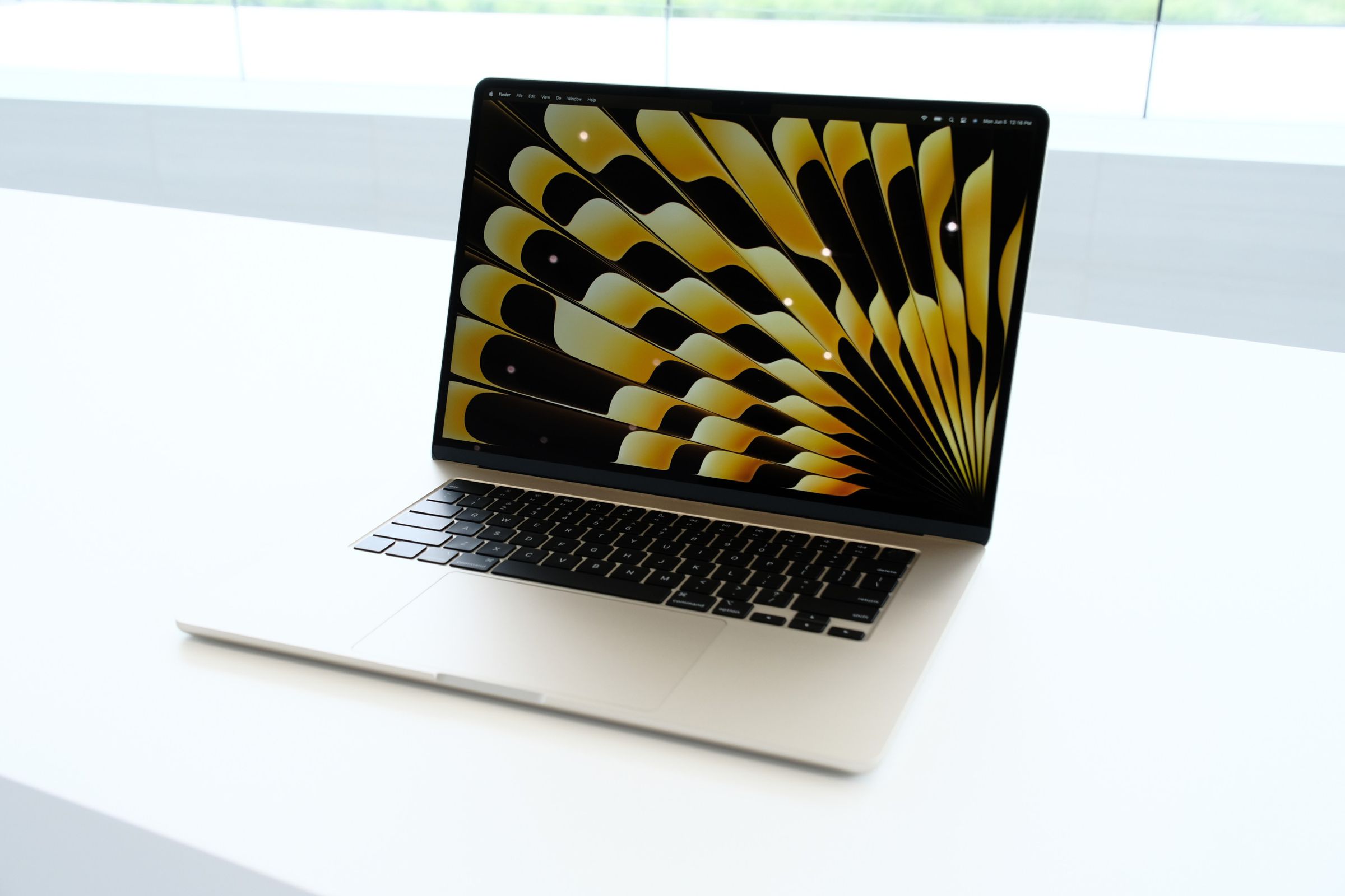 A Starlight 15-inch MacBook Air with its lid open on a white table.