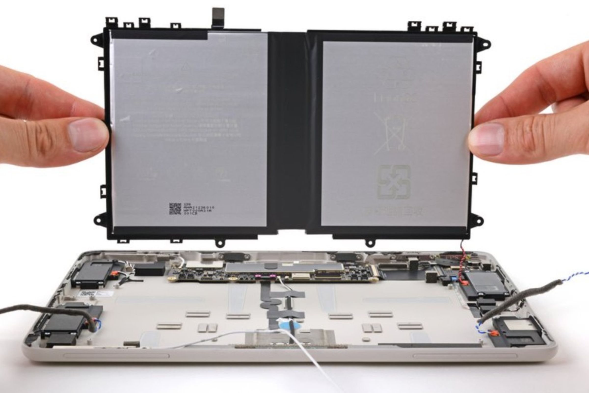 A picture of someone removing a Google Pixel tablet battery.