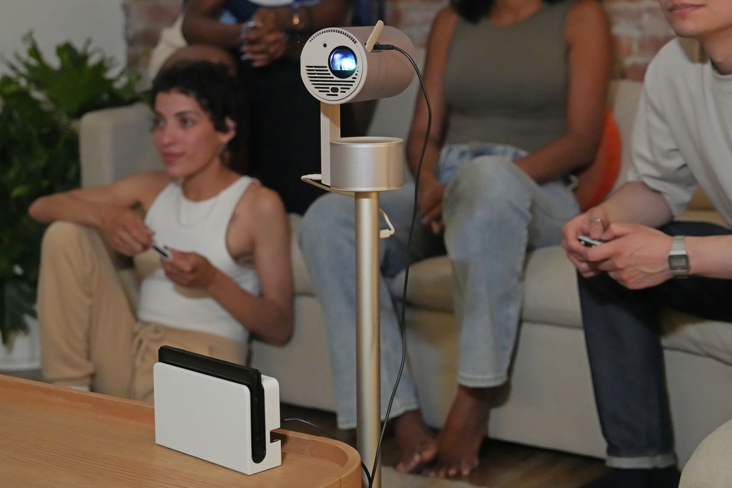 The Xgimi MoGo 3 Pro projector mounted to a stand with several people behind it.