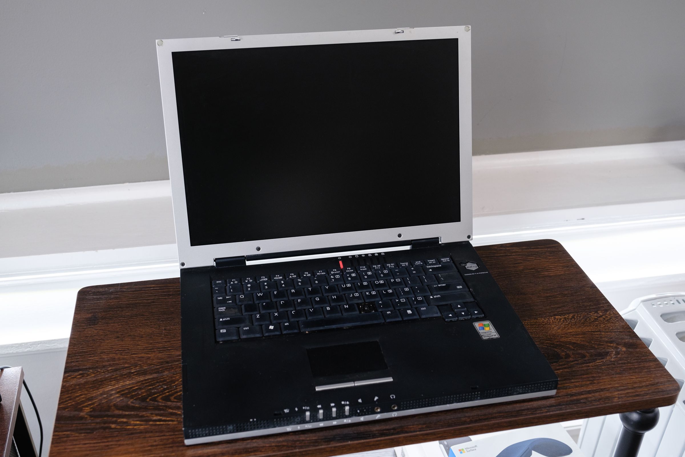 A silver and black VPR Matrix laptop open on a wooden table.
