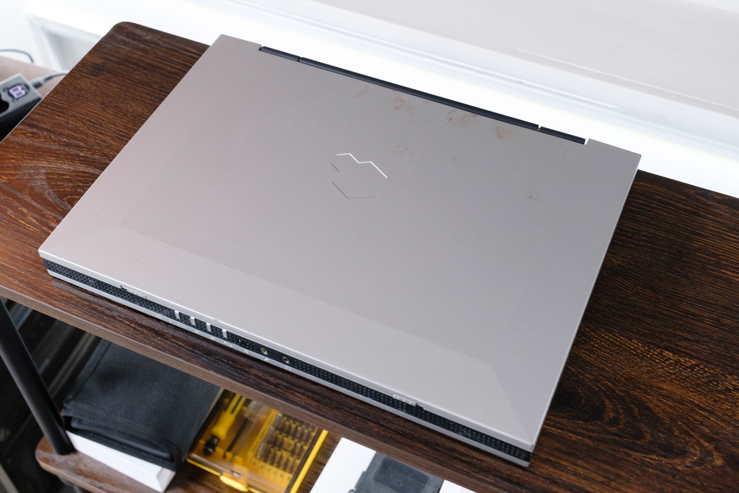 A silver laptop closed on a wooden table.