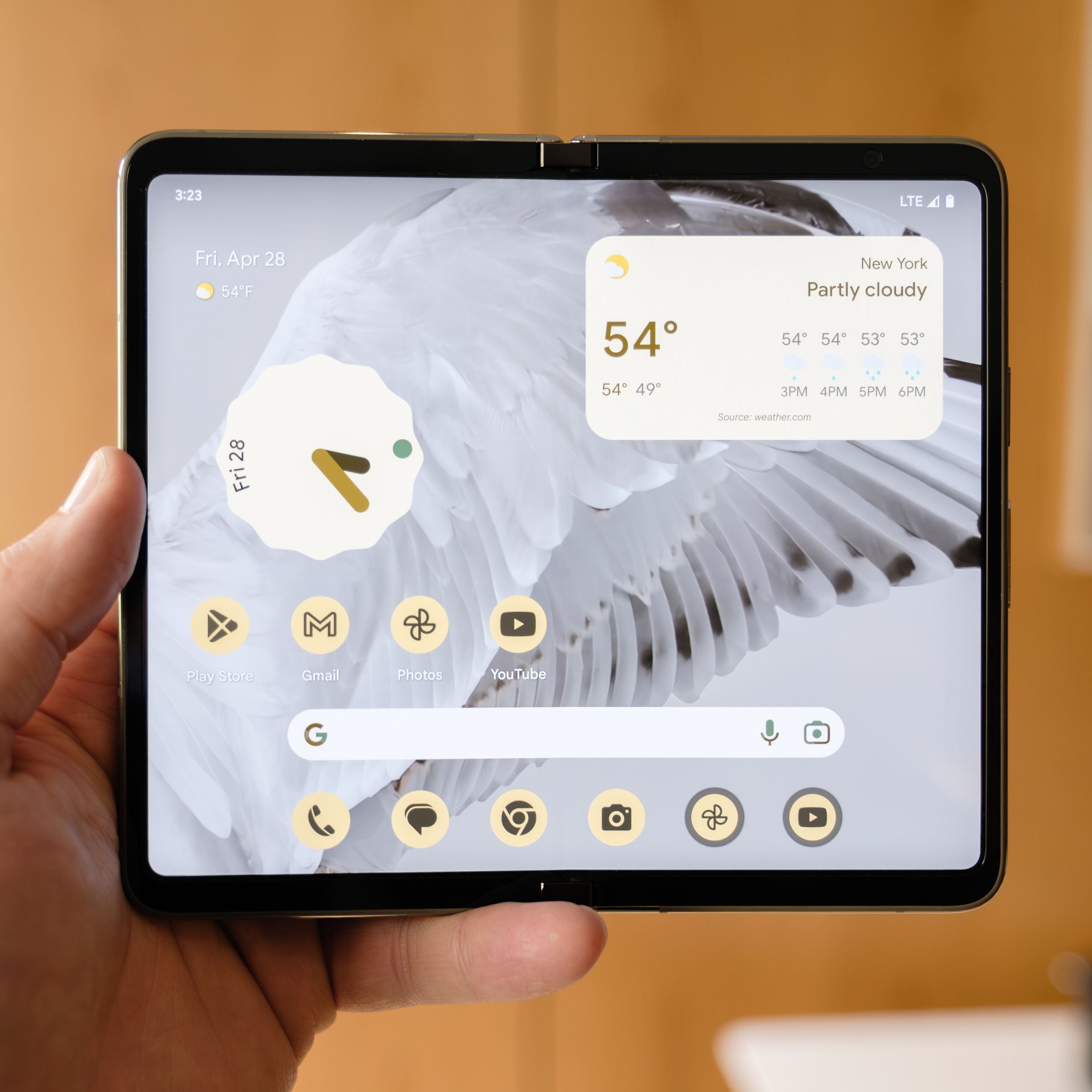 Google’s Pixel Fold opened in its tablet form, held up by a hand.