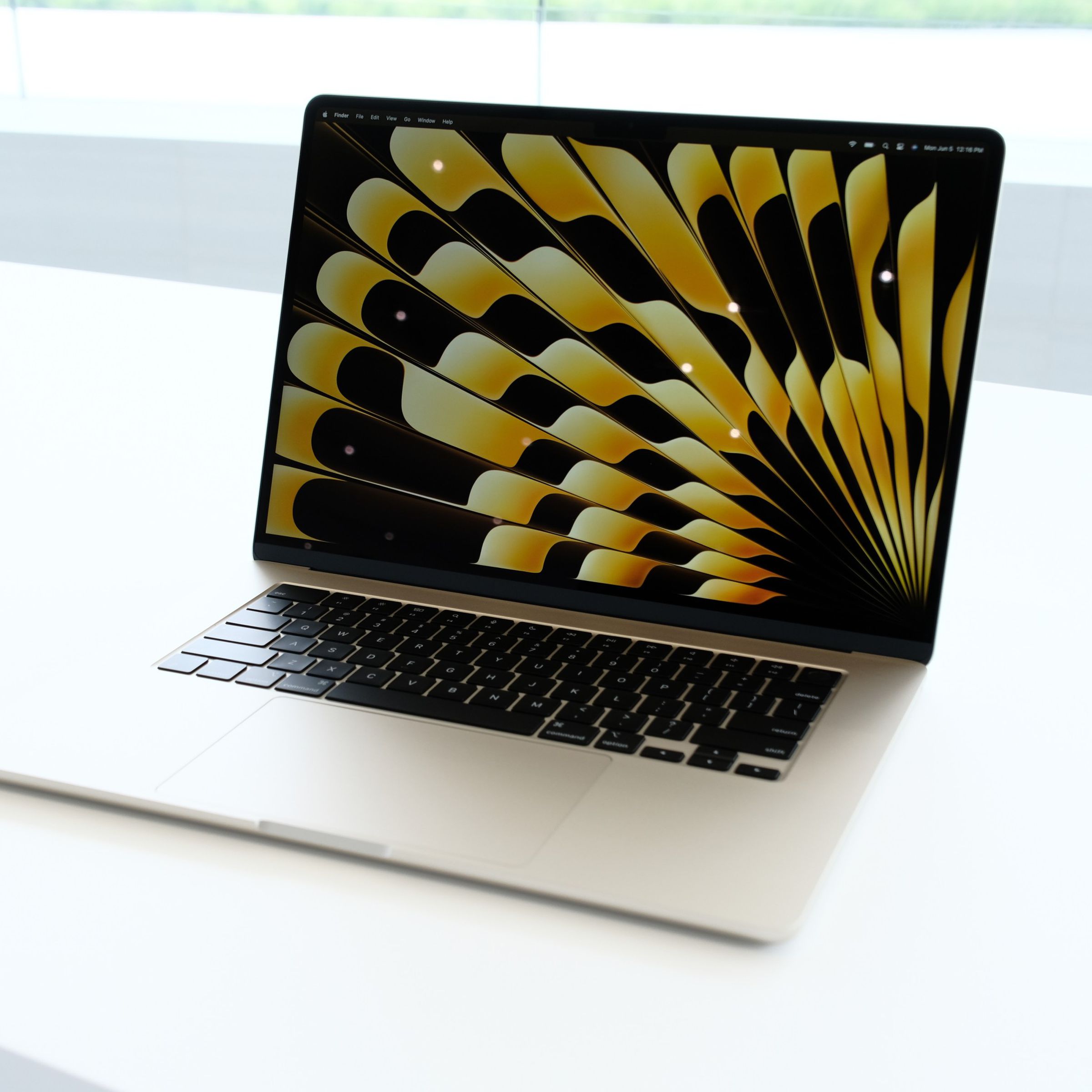 A Starlight 15-inch MacBook Air with its lid open on a white table.