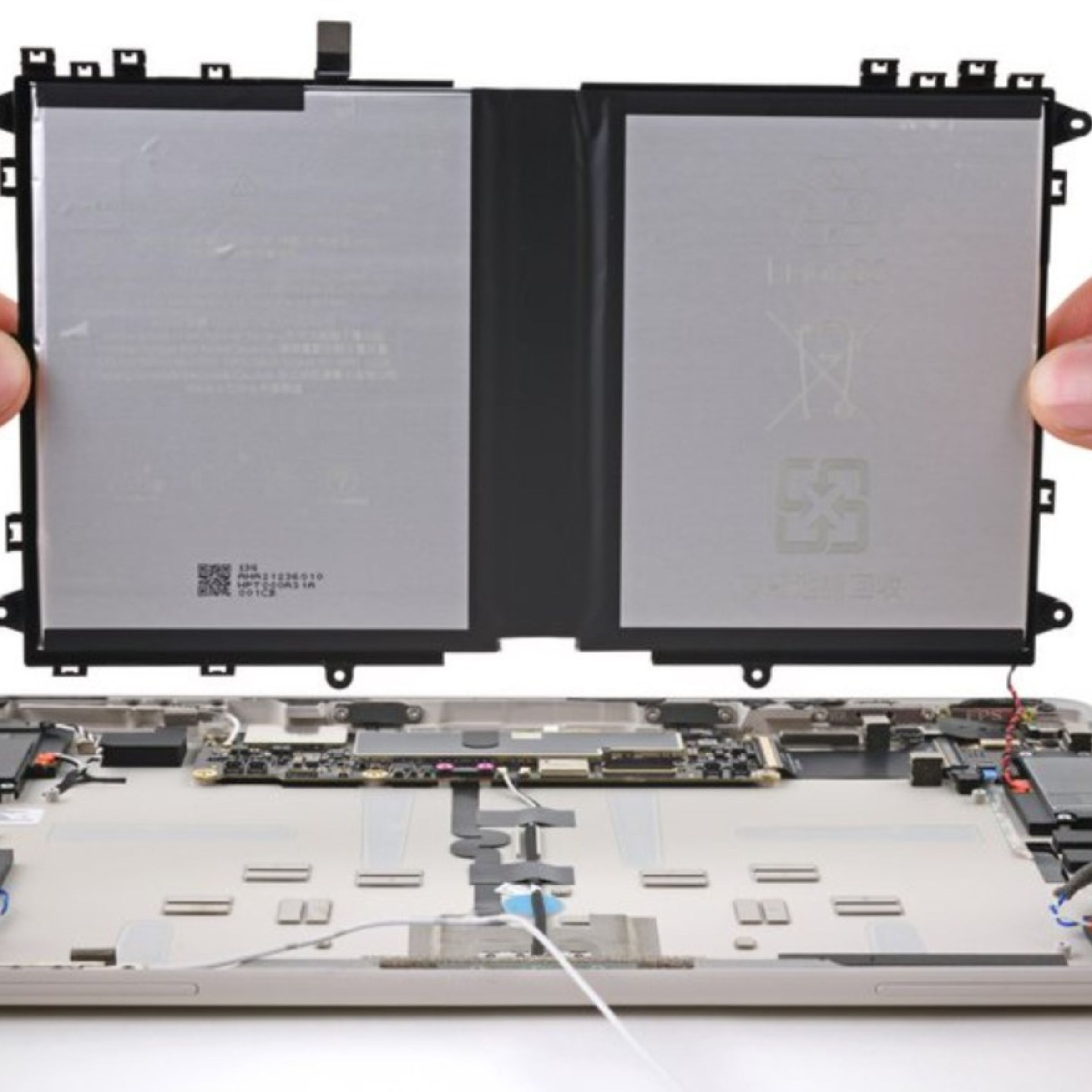 A picture of someone removing a Google Pixel tablet battery.