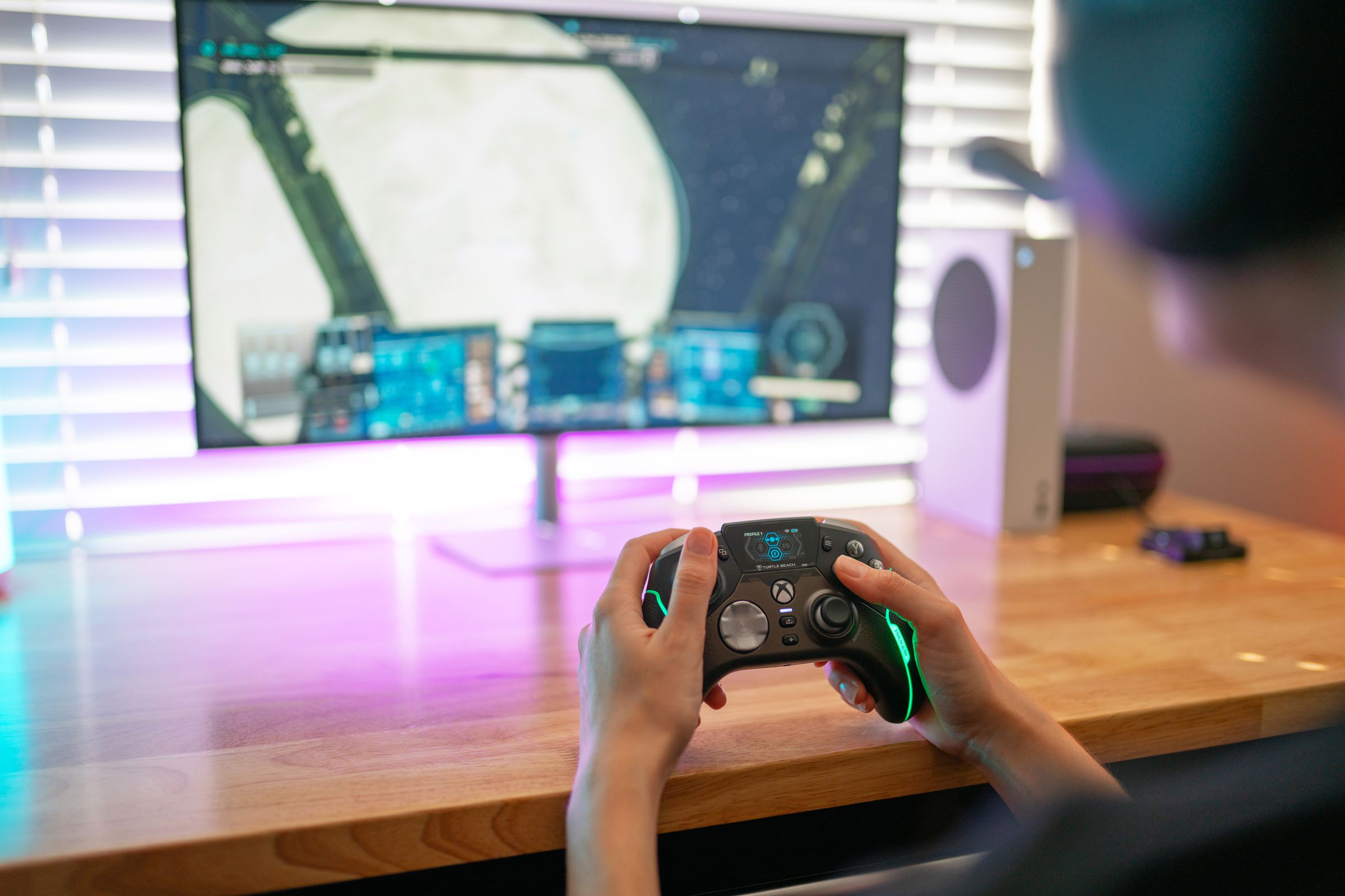 A person playing a game at a desk using a Turtle Beach Stealth Ultra controller.