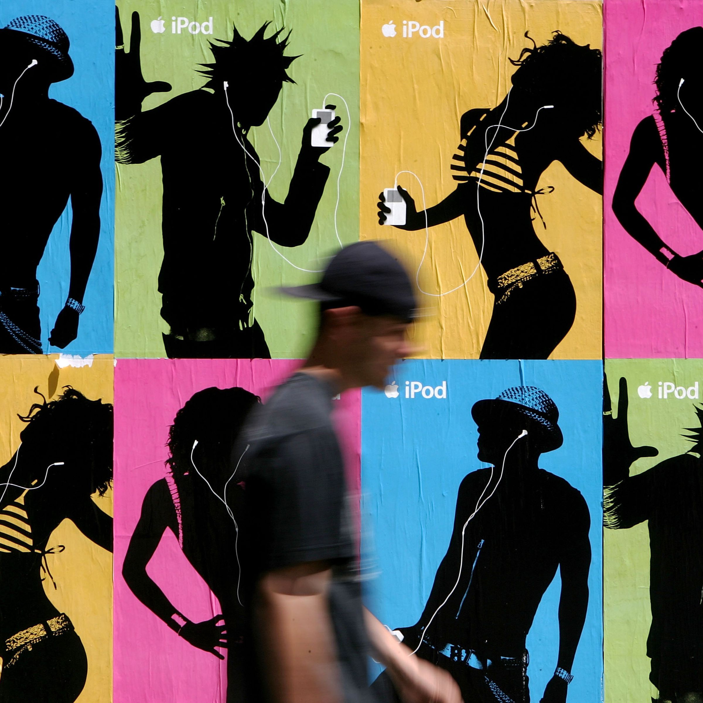 A pedestrian passes a wall covered with iPod advertisements in 2005