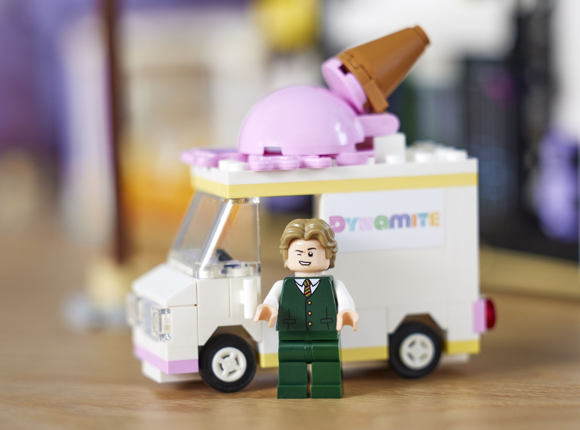 V Lego figurine winking in front of a Lego ice cream truck.