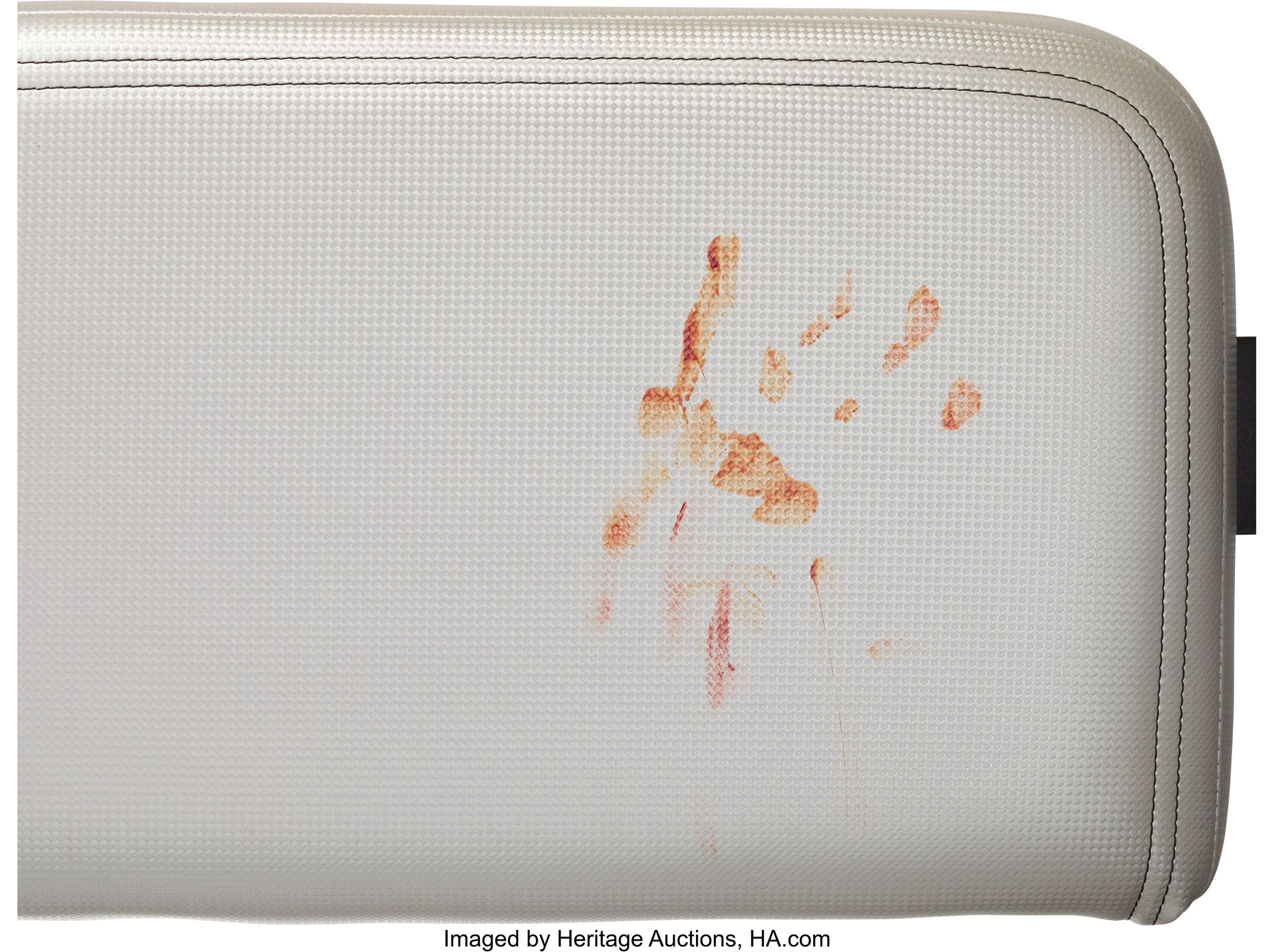 A picture of a seat cushion with a bloody handprint. 