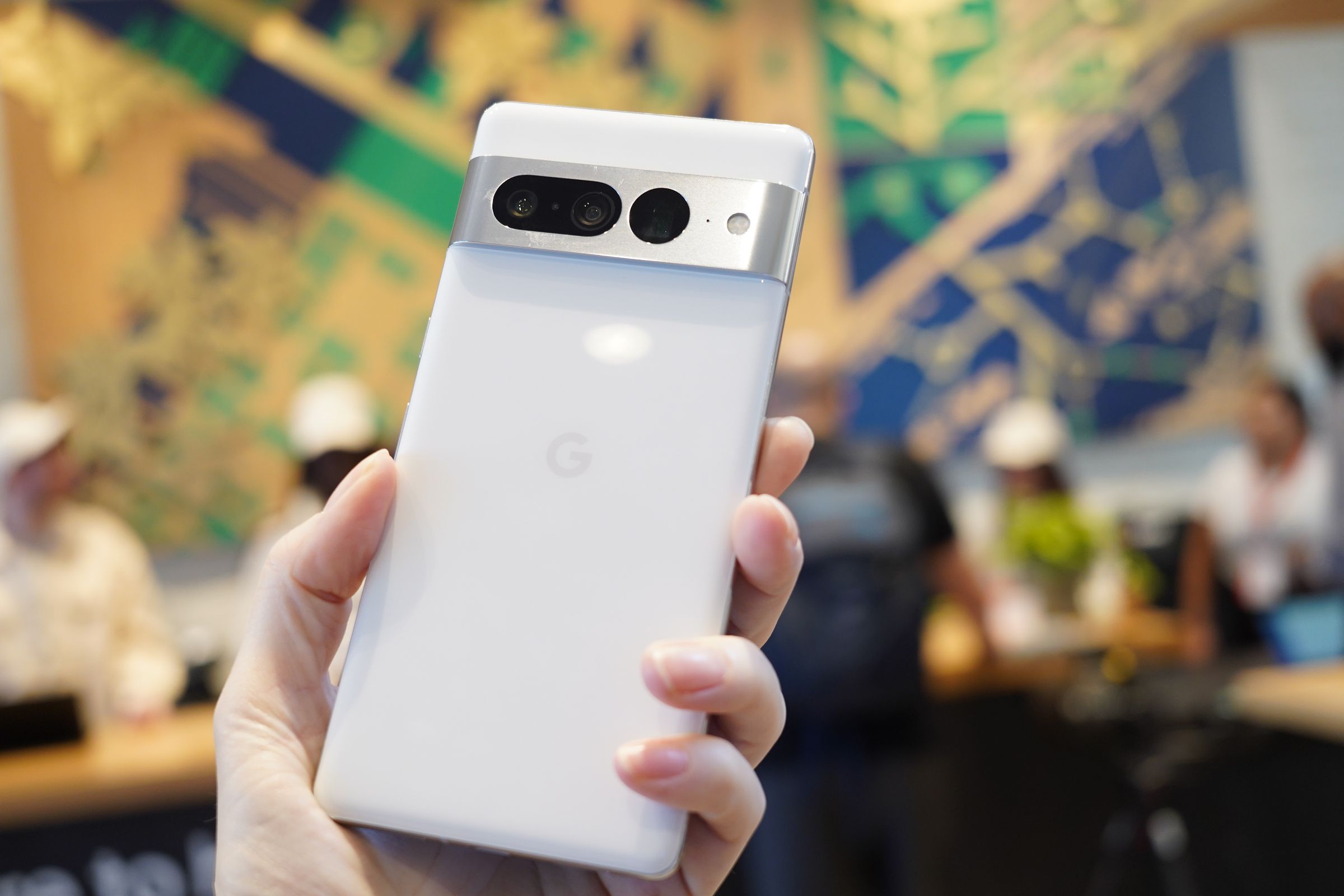 The Google Pixel 7 Pro phone with its back turned, revealing its white design and three rear-facing cameras.