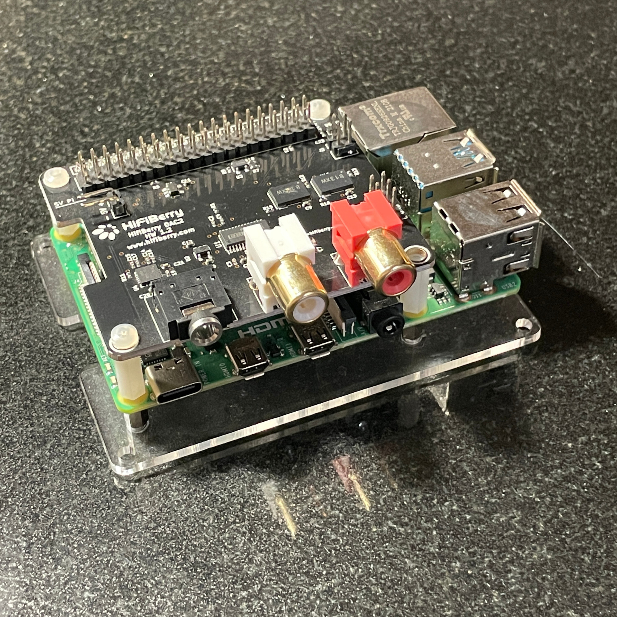 A photo of a caseless Raspberry Pi 4b with a HifiBerry DAC hat on top.