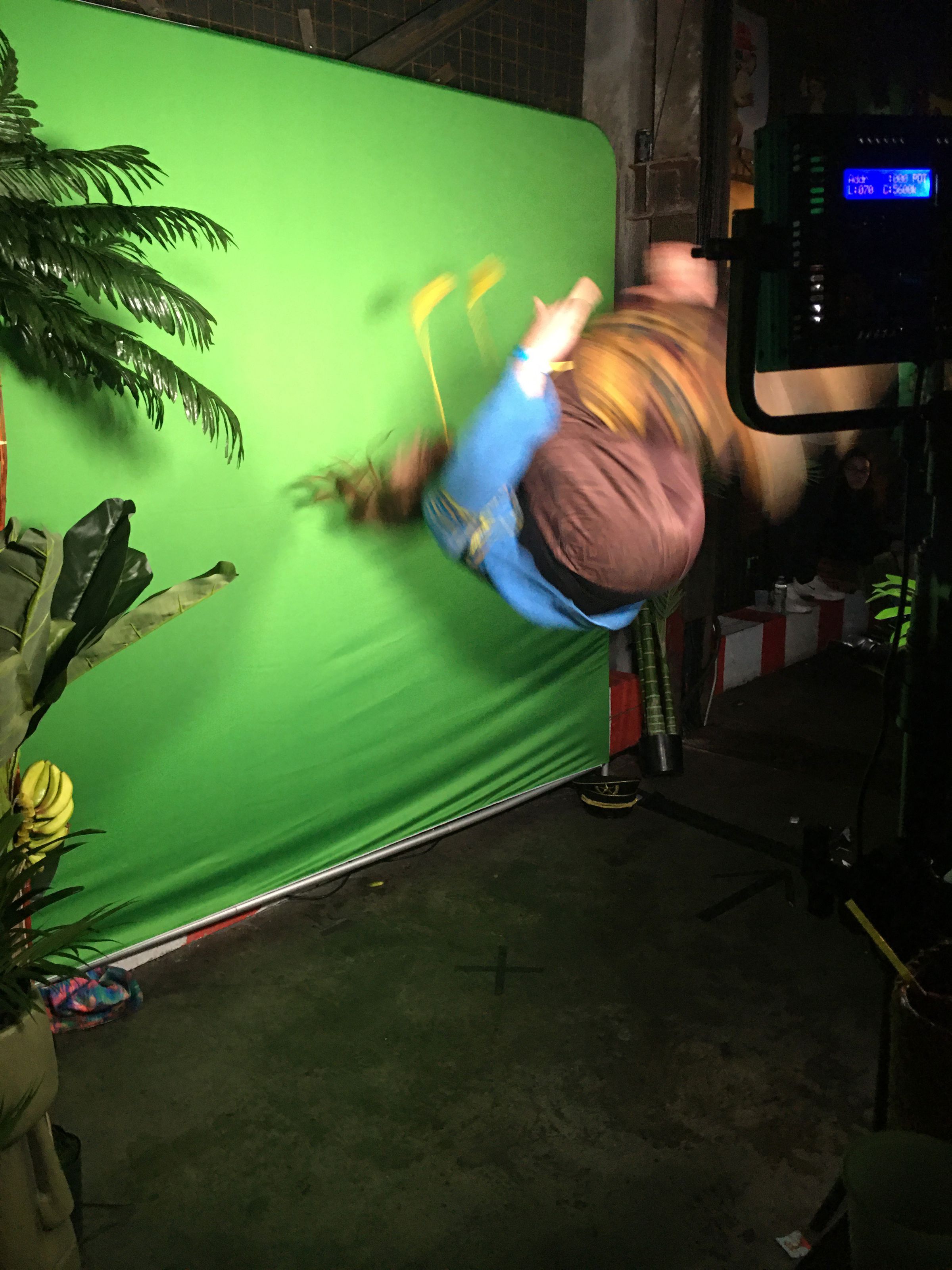 A Bored Ape attendee attempts a backflip at the photo booth