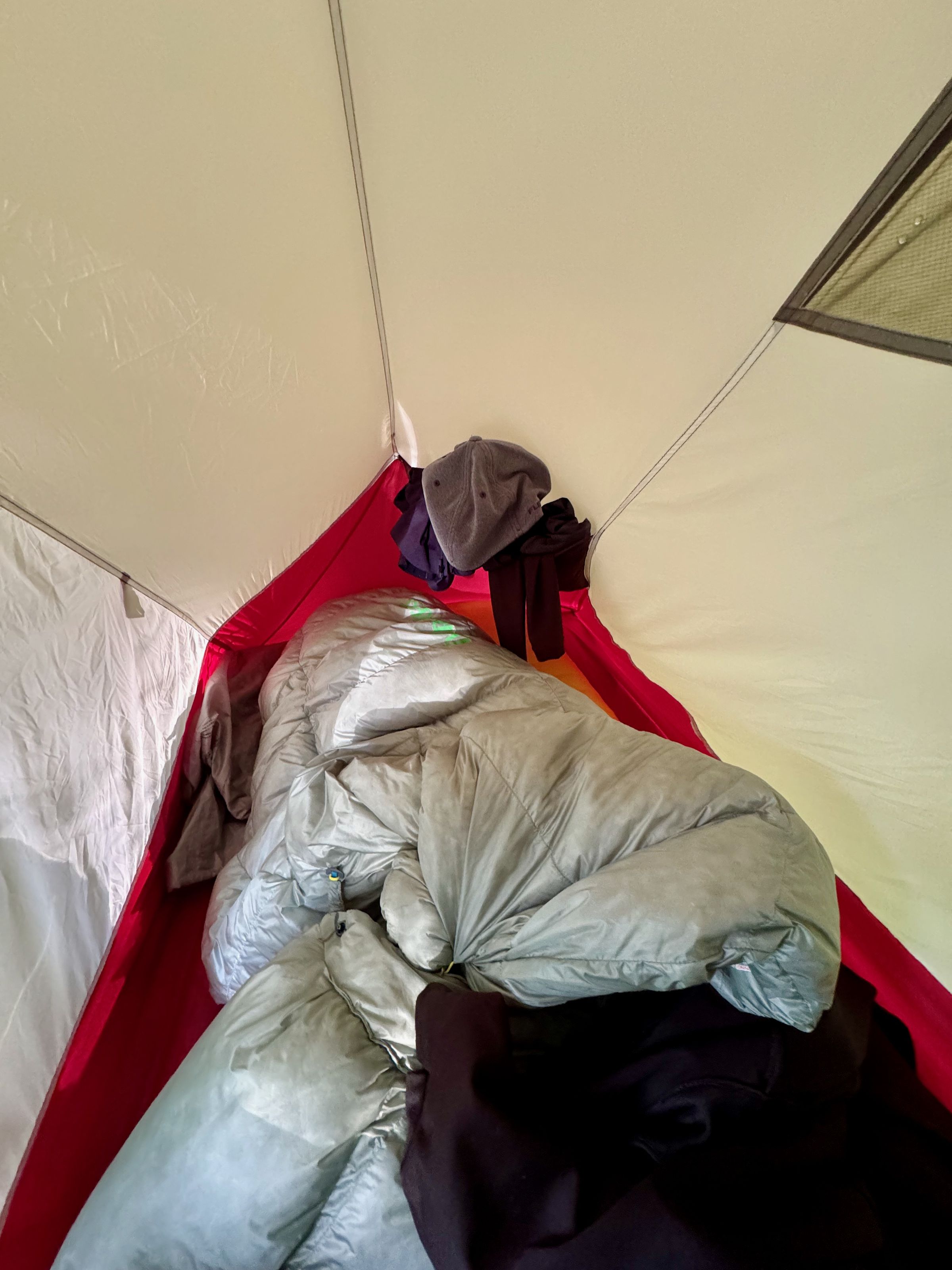 <em>And the bottom of my tent, with the quilt stretched over the Thermarest air mattress to help it stay in place at night. Also visible is a top-right corner pocket stuffed with things that needed to dry.</em>
