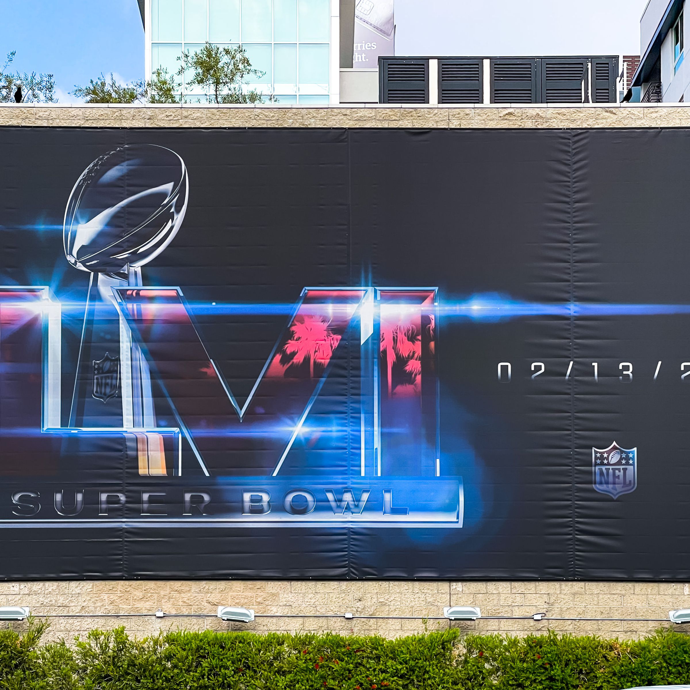 A poster in Los Angeles promoting Super Bowl 56, featuring the Super Bowl LVI logo, an image of the Vince Lombardi Trophy, the NFL’s logo, and the date for the Super Bowl — 2/13/22.