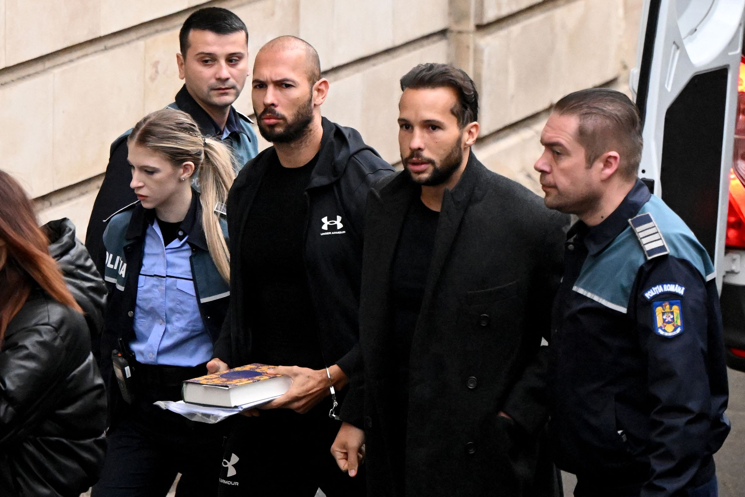 Andrew Tate (3rd R) and his brother Tristan Tate (2nd R) escorted by police to a court hearing in Bucharest on January 10th, 2023 for their appeal against pre-trial detention for alleged human trafficking, rape, and forming a criminal group.