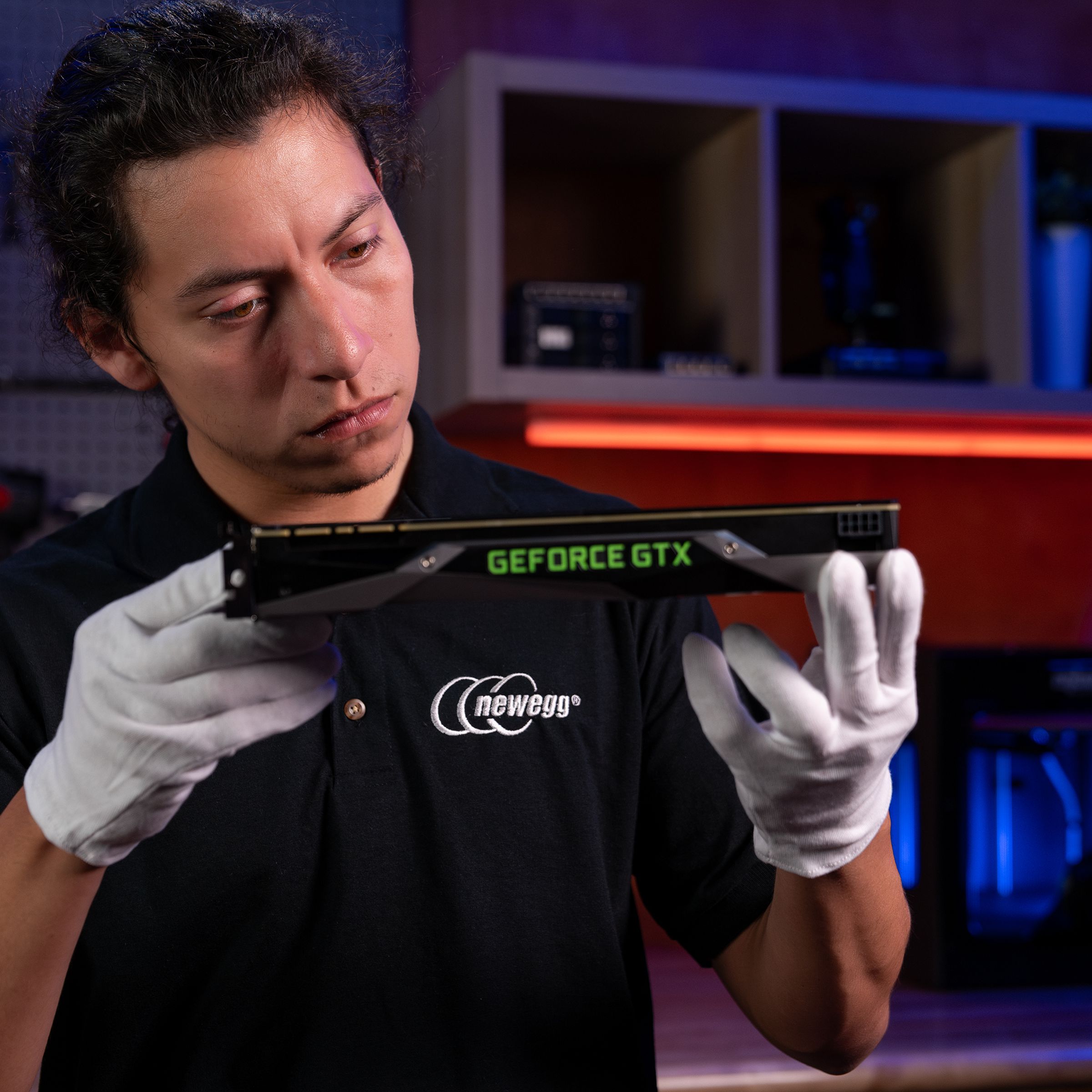Image of a serious-looking man with black hair and white cotton gloves examining an Nvidia Geforce GTX graphics card. Hey, wait a minute, those aren’t even eligible for this program!