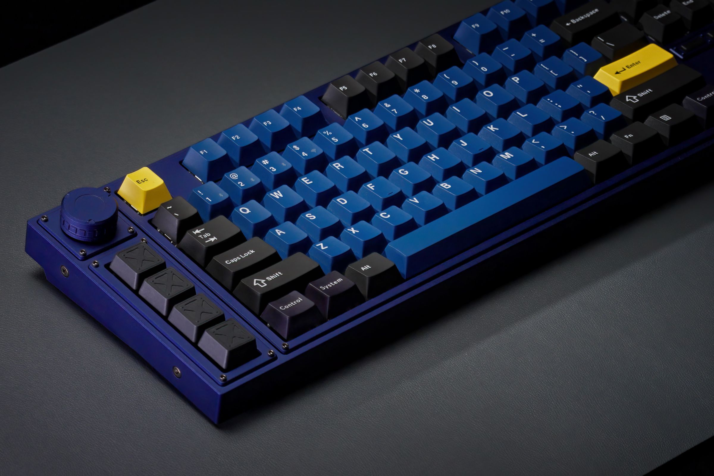 A blue, yellow, and black keyboard on a desk.