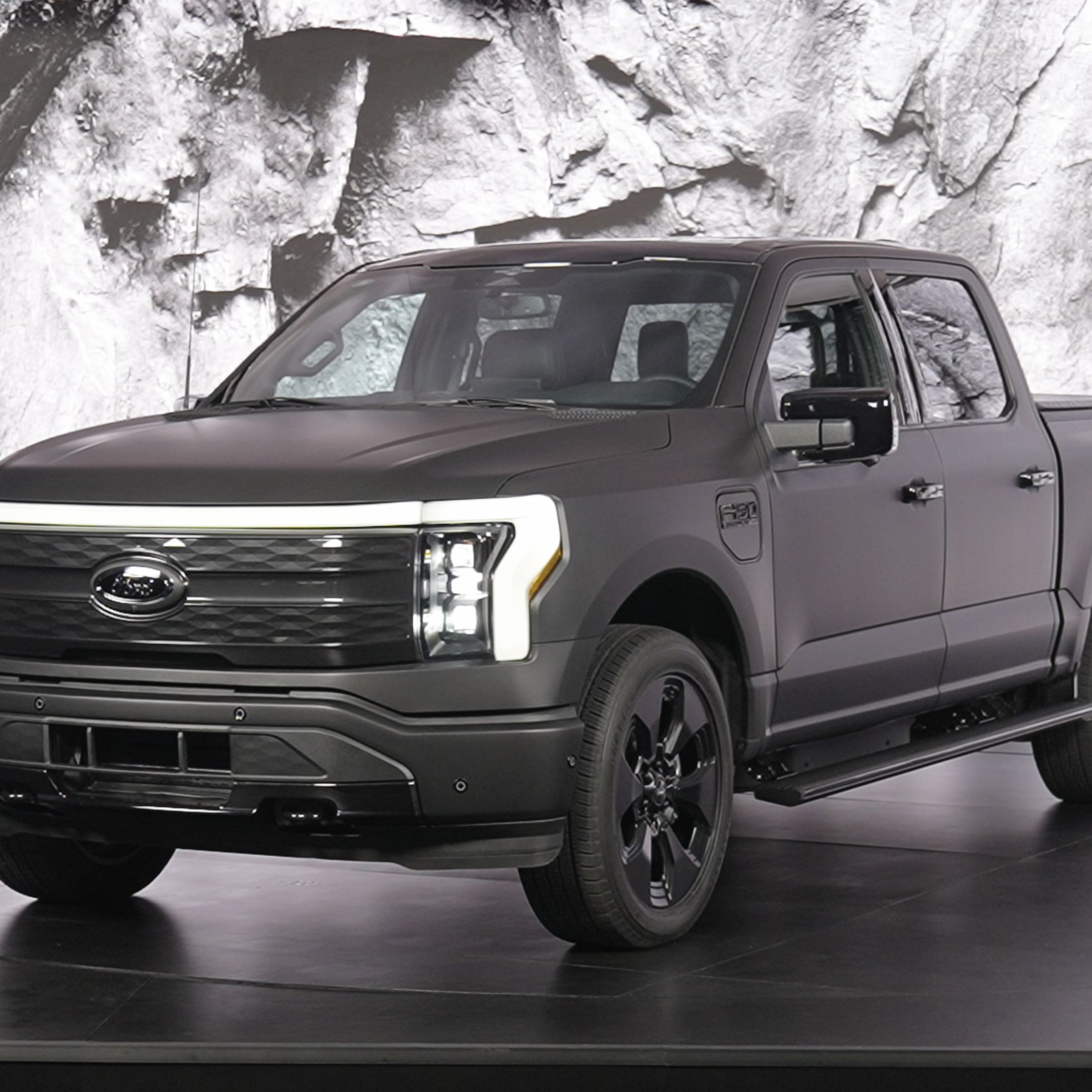 F-150 Lightning truck on a rotating stage with lighted backdrop