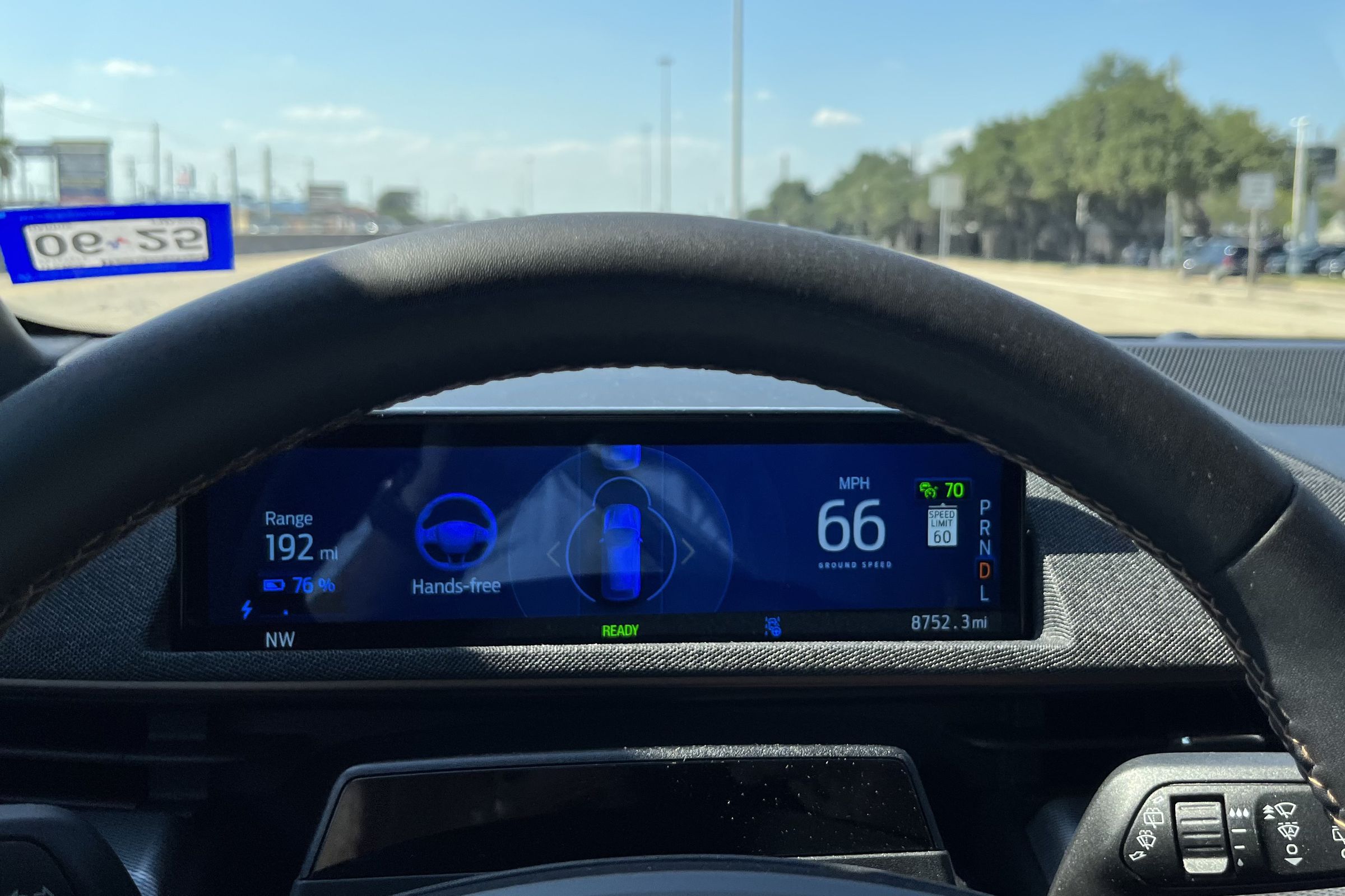 The driver screen seen through the steering wheel in a Mach-E, the screen says “hands-free”