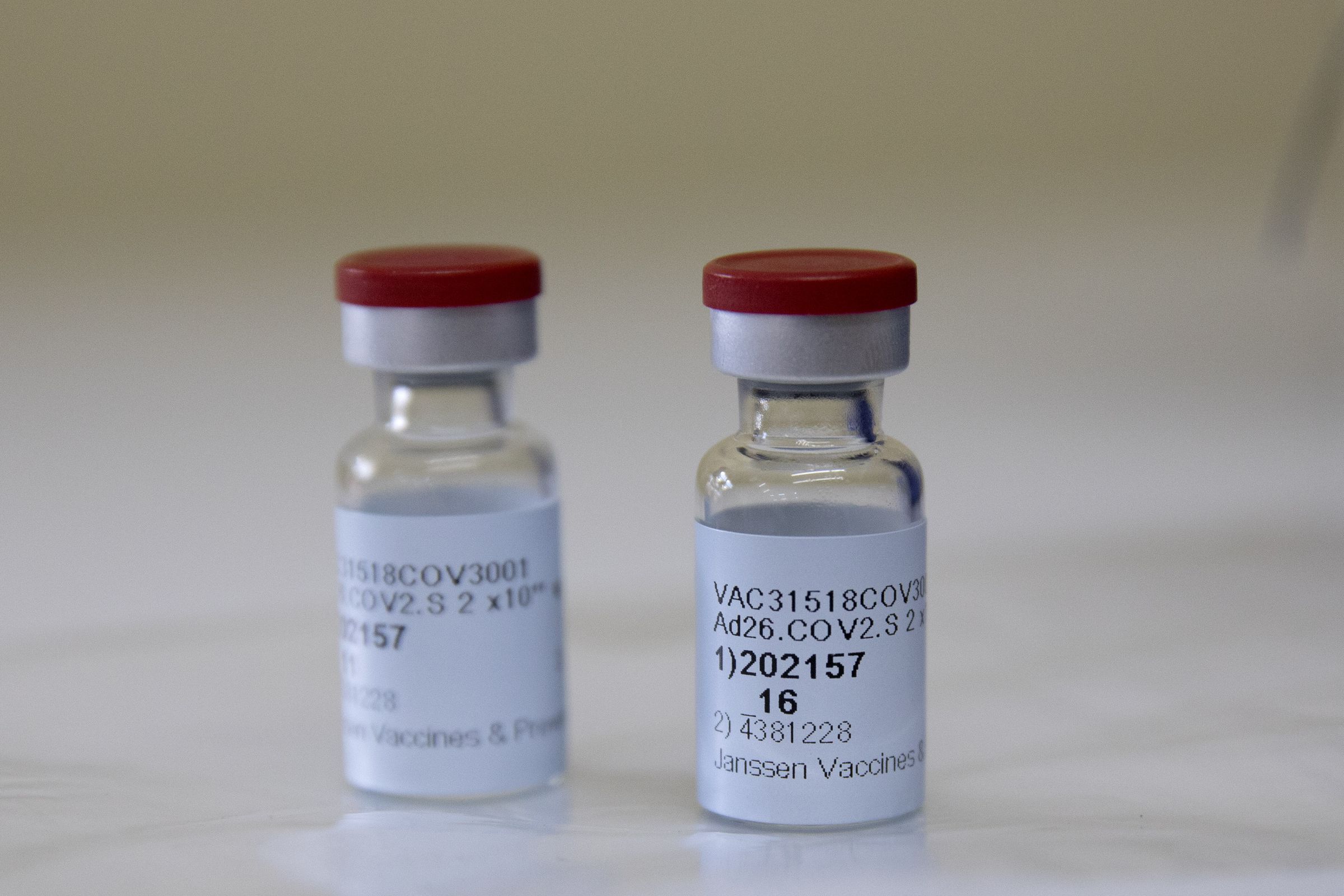 Two Johnson &amp; Johnson vaccine vials on a surface.