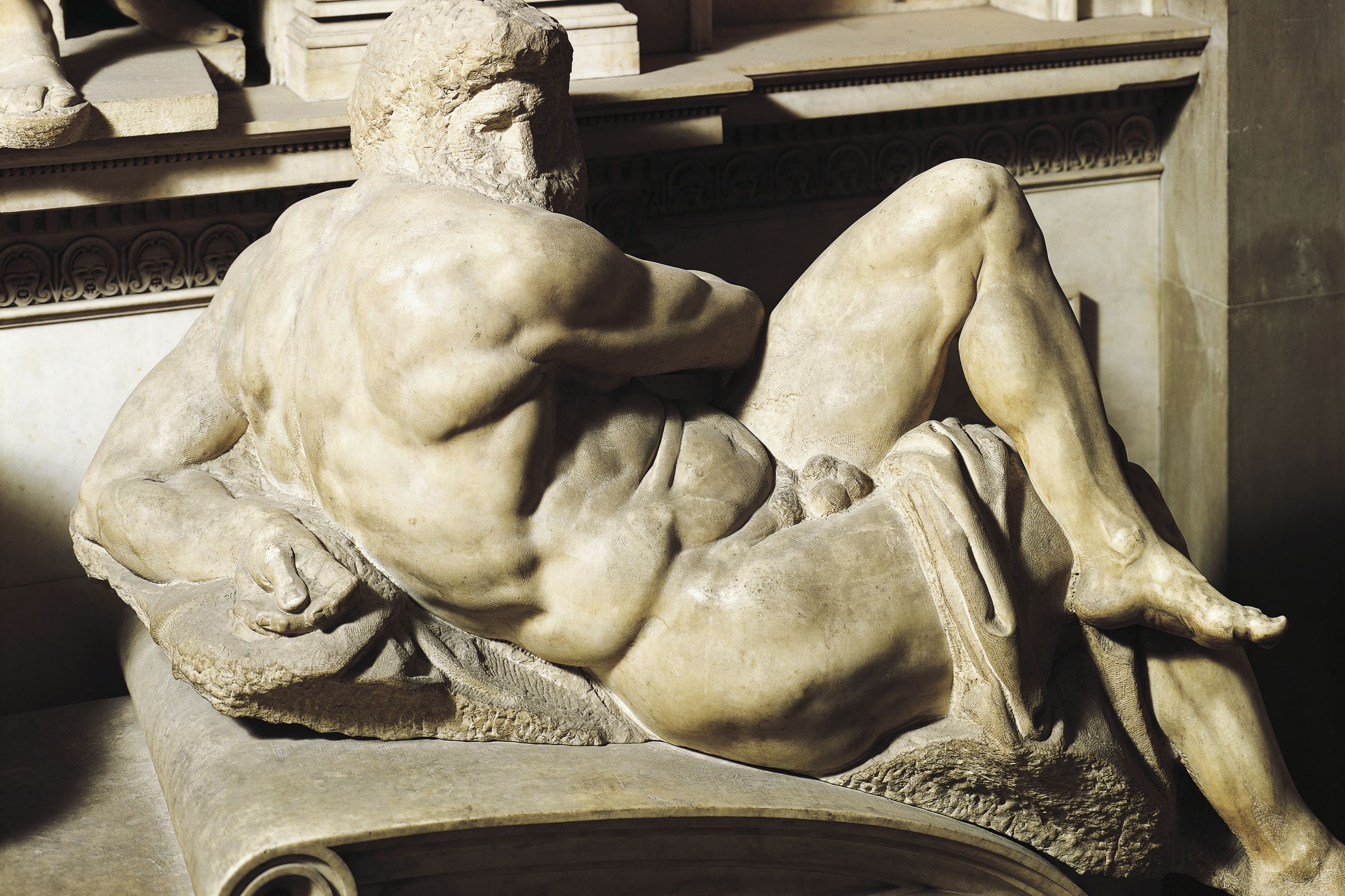 A marble sculpture of a nude bearded man reclining