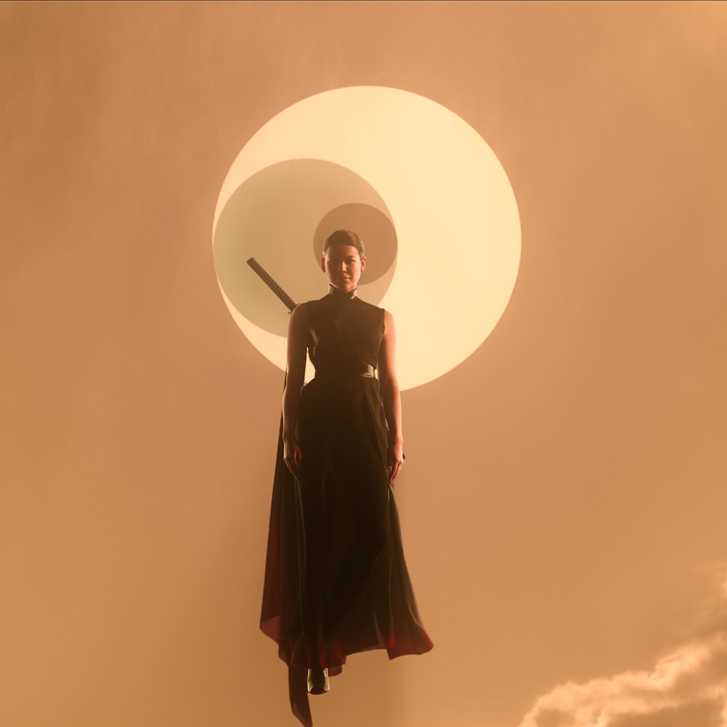 A woman in a formfitting, sleeveless back outfit accented with a flowing black cape, and a sheathed sword on her back. The woman is floating into a pale, rust-colored sky in which the sun is being eclipsed by two smaller celestial bodies.