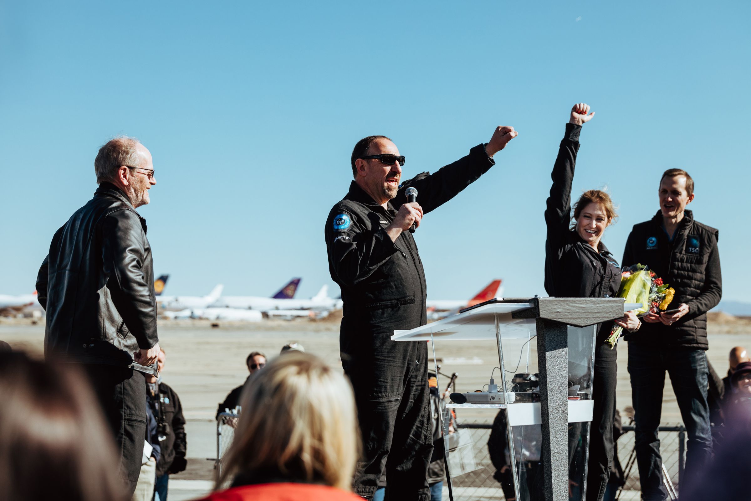 Beth Moses celebrating after the flight with the two pilots, Dave Mackay (L) and Mike ‘Sooch’ Masucci (C), as well as Virgin Galactic CEO George Whitesides (R)