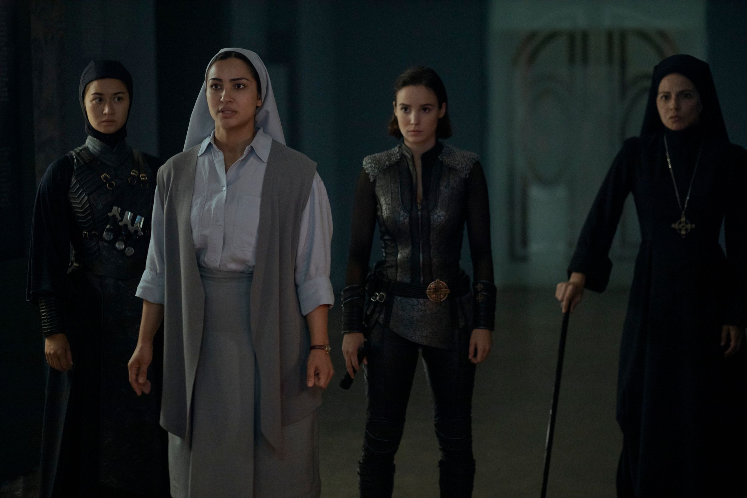 Rahibe gibi giyinmiş dört kadın yan yana duruyor.
